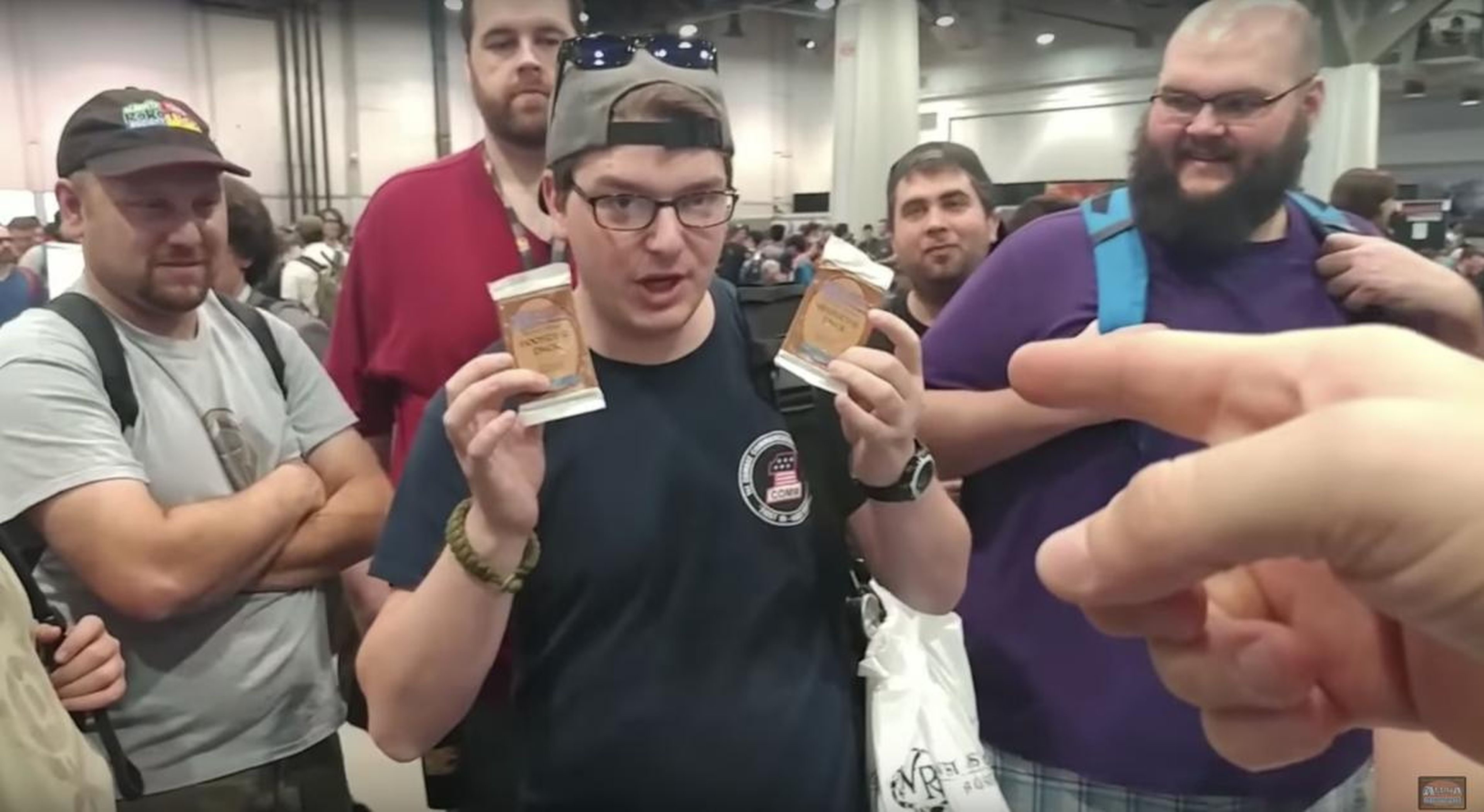A man holding up packs of "Magic: The Gathering" cards at a Las Vegas showcase in April.