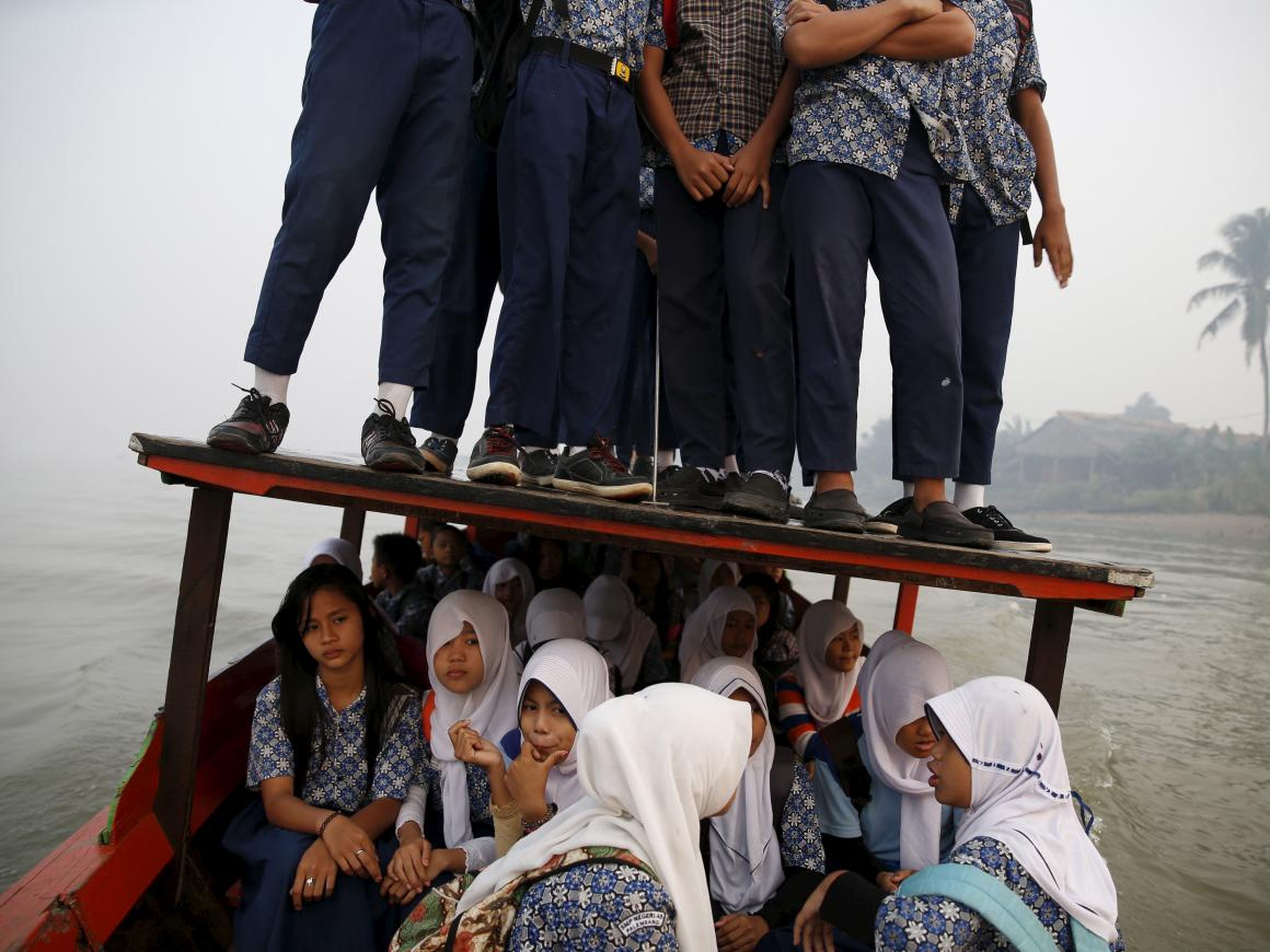 In other parts of the country, the wooden boats that ferry kids across the Musi River sometimes fill up to the extent kids must stand on the roof.