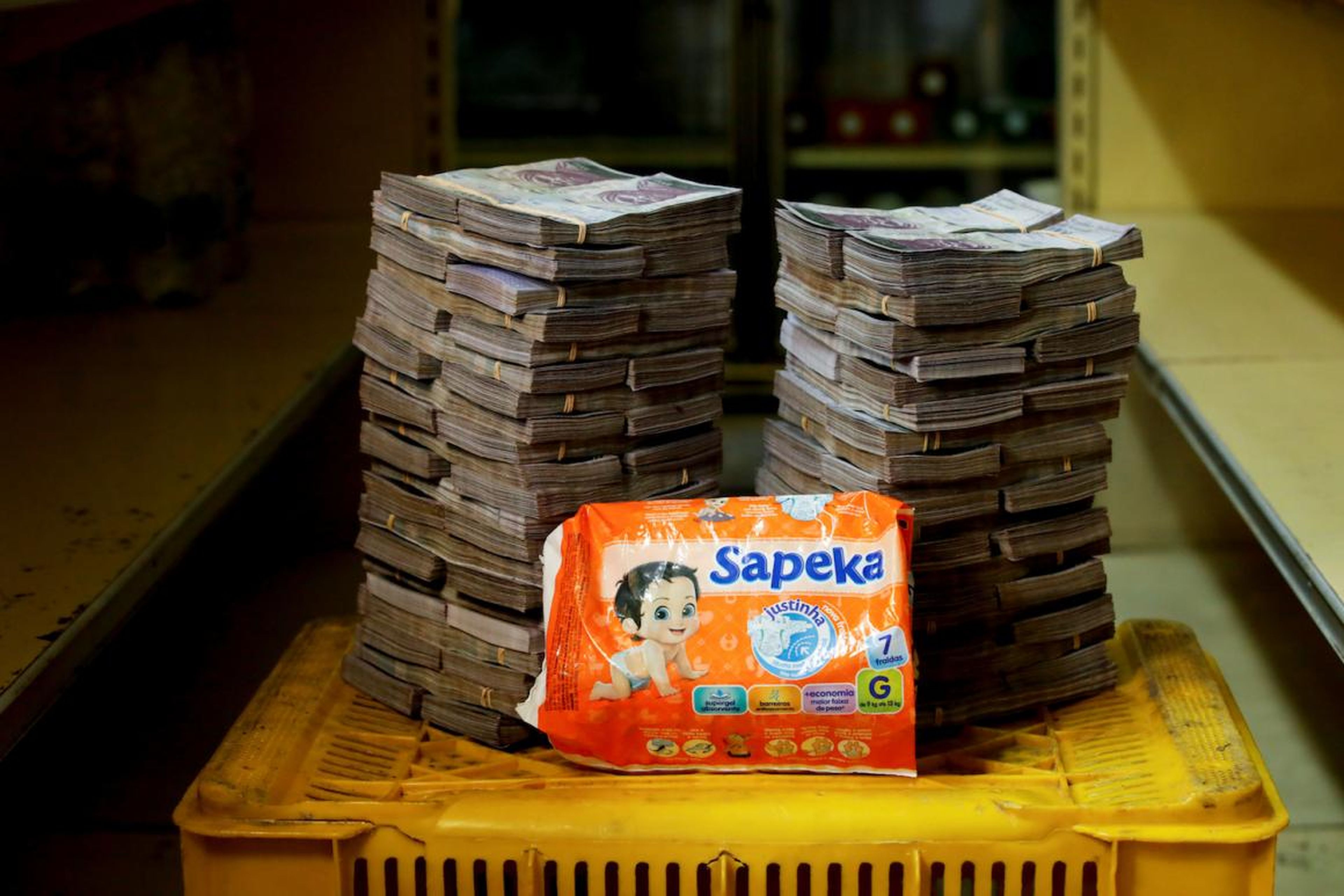A package of diapers is pictured next to 8,000,000 bolivars, its price and the equivalent of 1.22 USD, at a mini-market in Caracas.