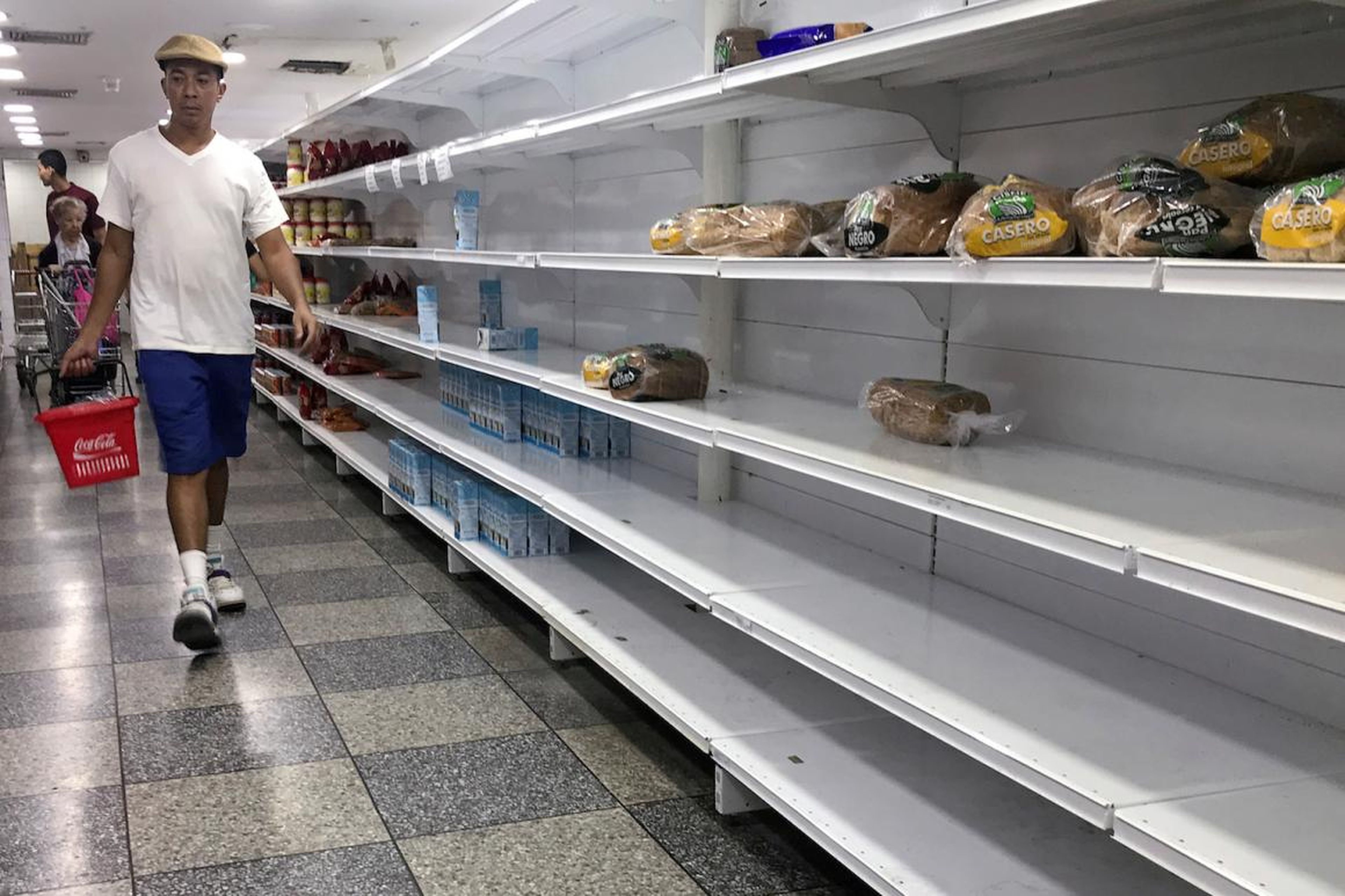 People walk looking for products at a supermarket in Caracas, Venezuela.
