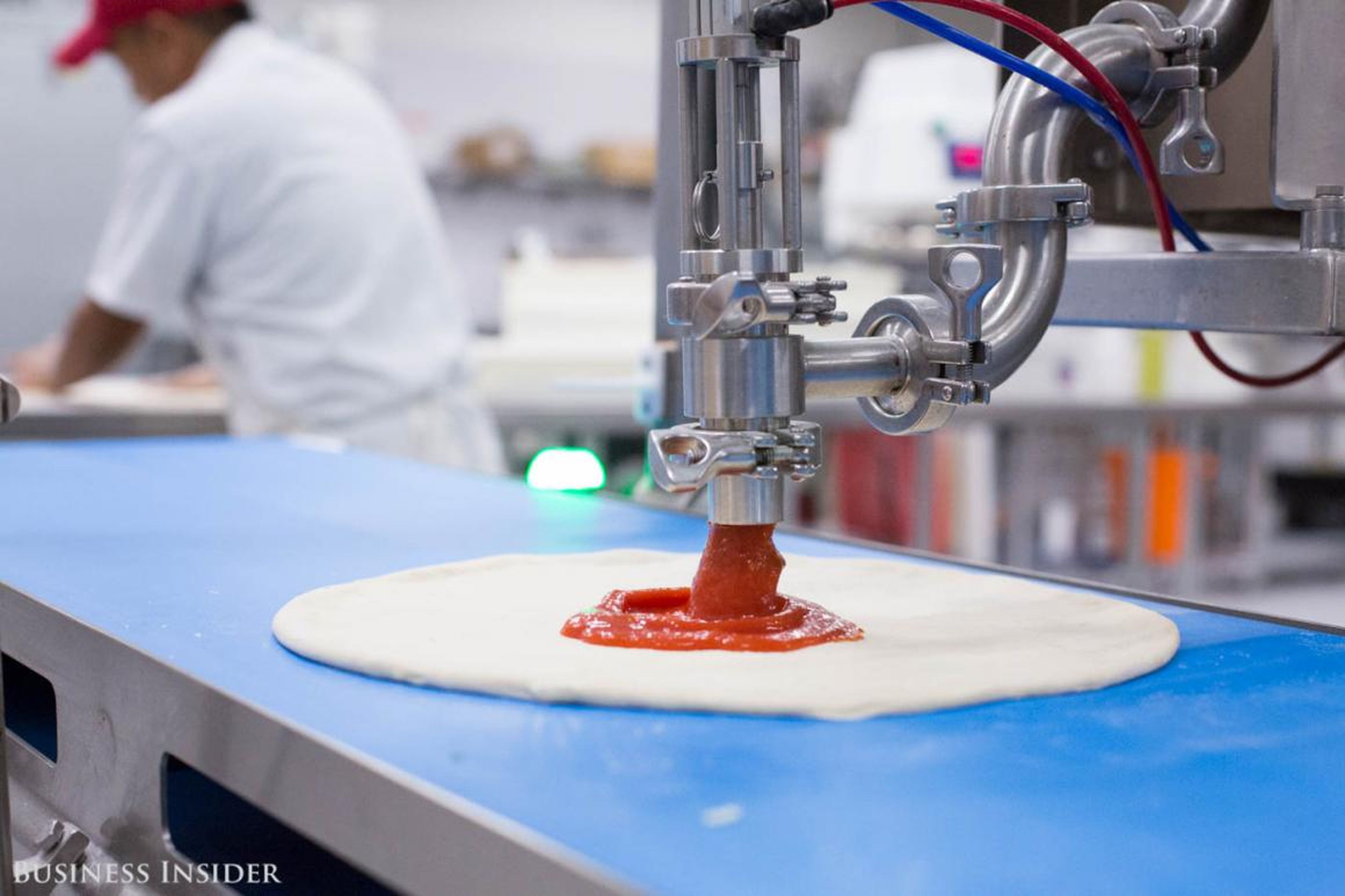 The pizza crust slides down the conveyor belt and lands under one of two sauce dispensers, named Giorgio and Pepe. They release different amounts of sauce based on the customer's order.