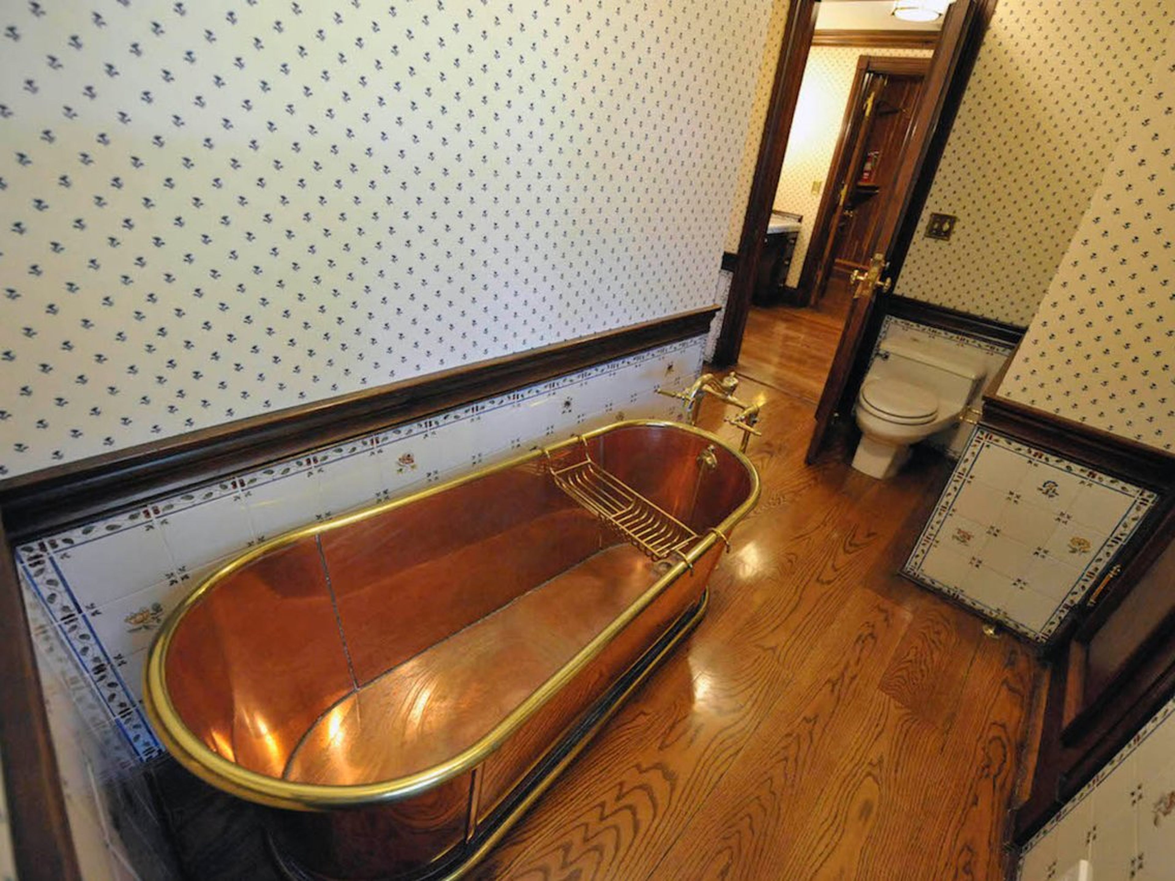 Aquí hay uno de los baños conectados al pasillo. Hay un total de ocho en la residencia principal. Este cuenta con una bañera de cobre