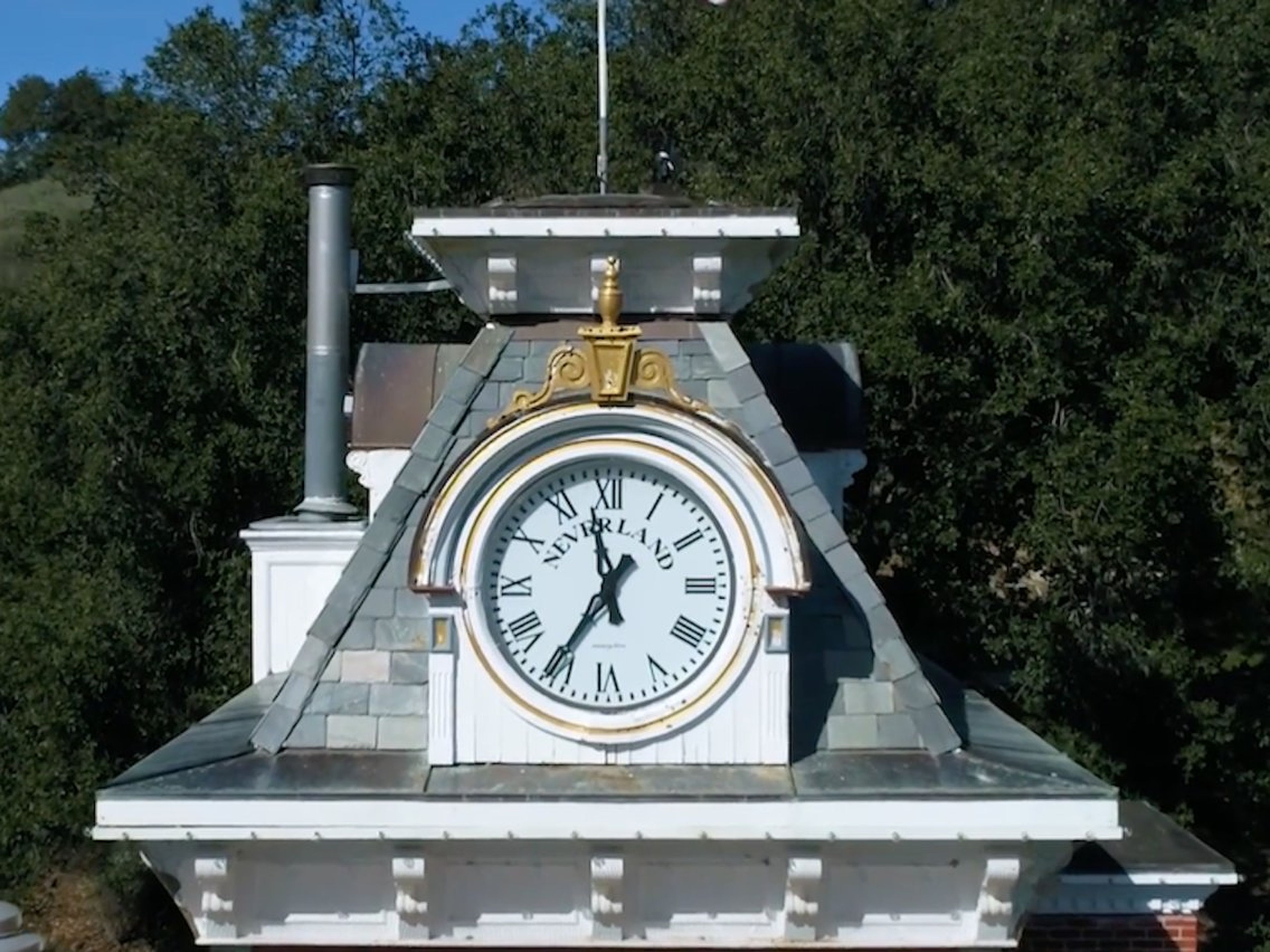 Aquí hay un gran reloj que se encuentra encima de la estación de tren con "NEVERLAND" en grandes letras negras