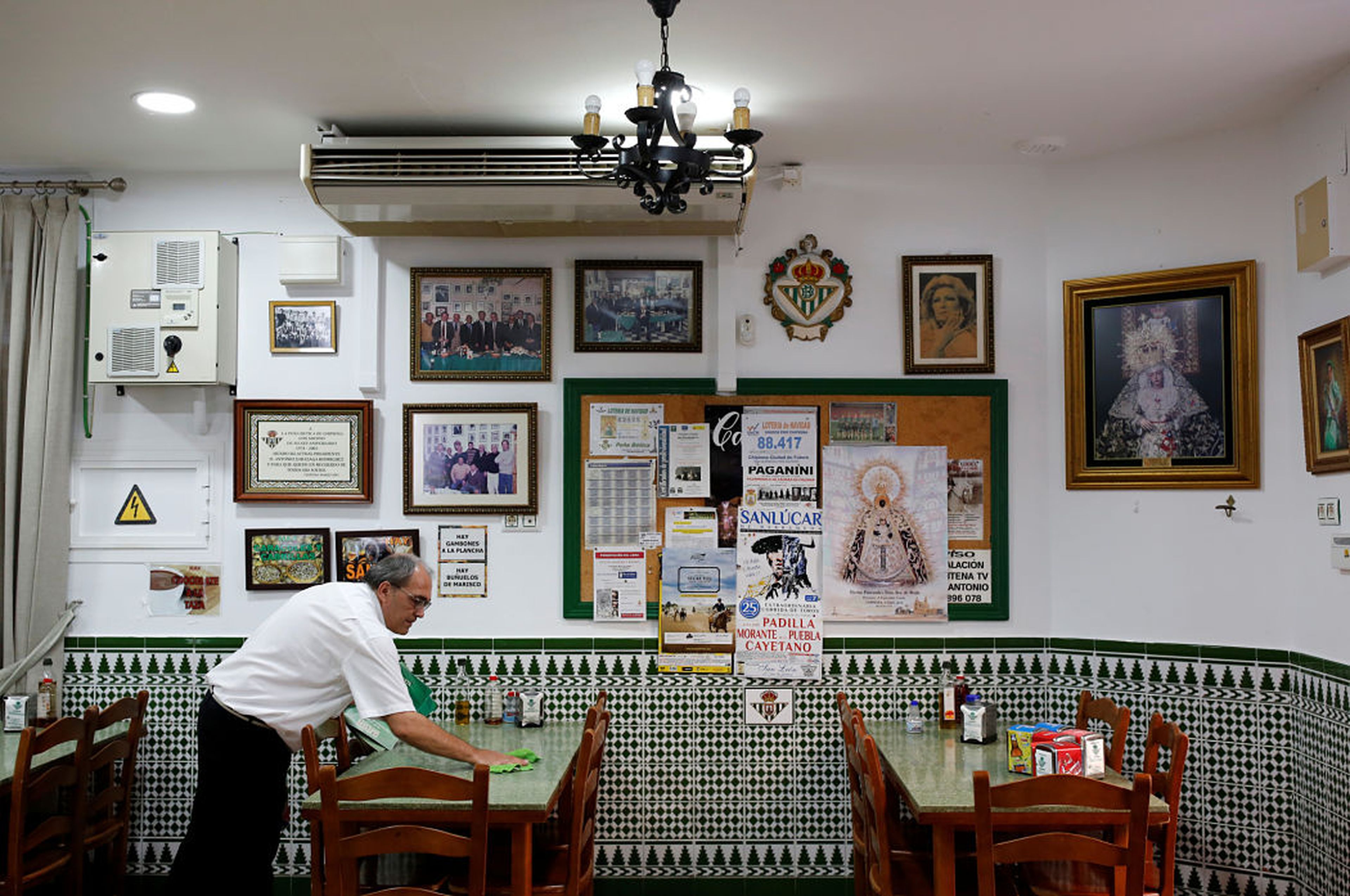 Un camarero prepara las mesas de un restaurante en Chipiona (Cádiz)