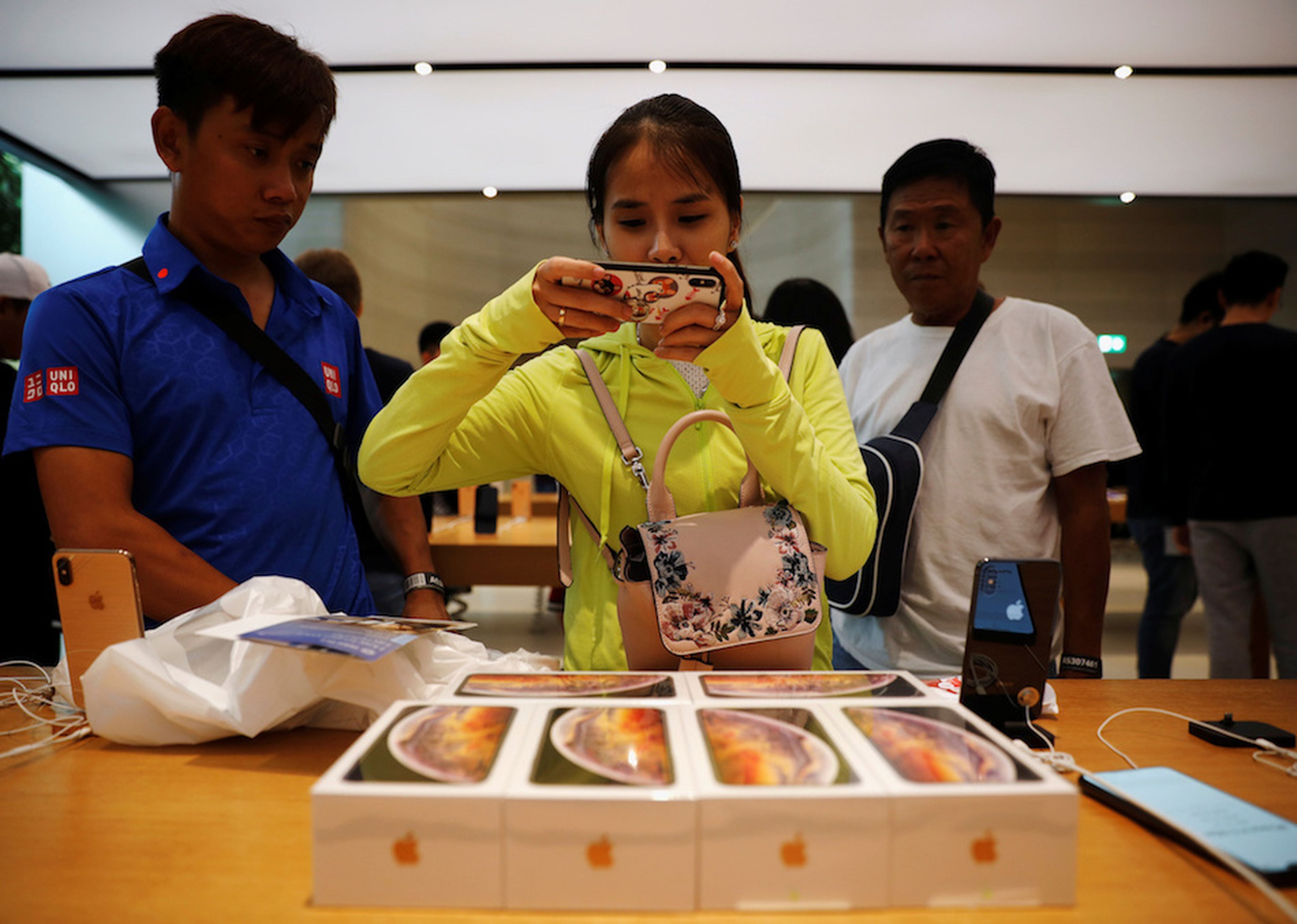 Clientes de vietnam toman fotos del iPhone XS en una Apple Store de Singapur