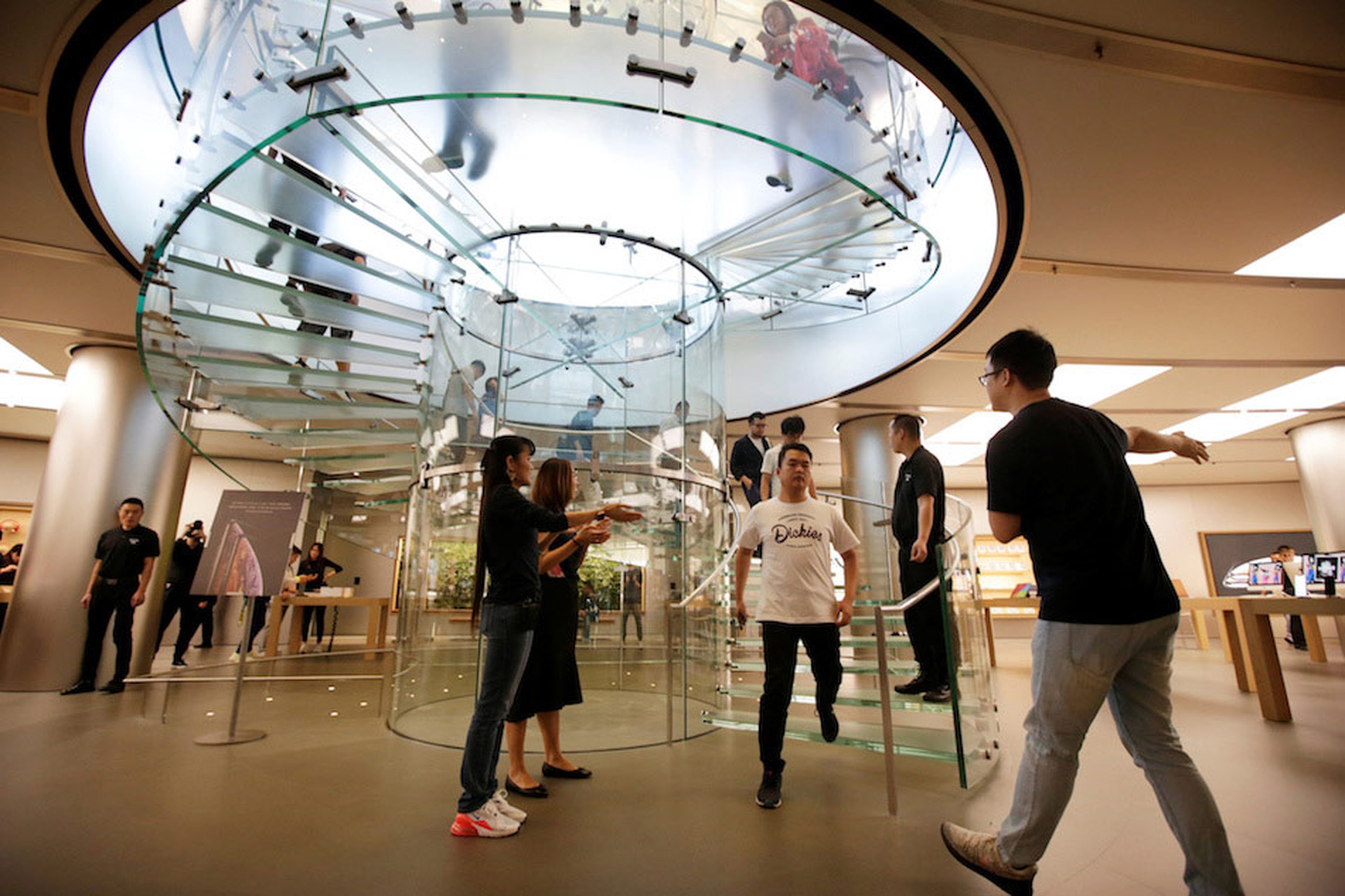 Los empleados aplauden a los primeros clientes de una Apple Store en Pekín