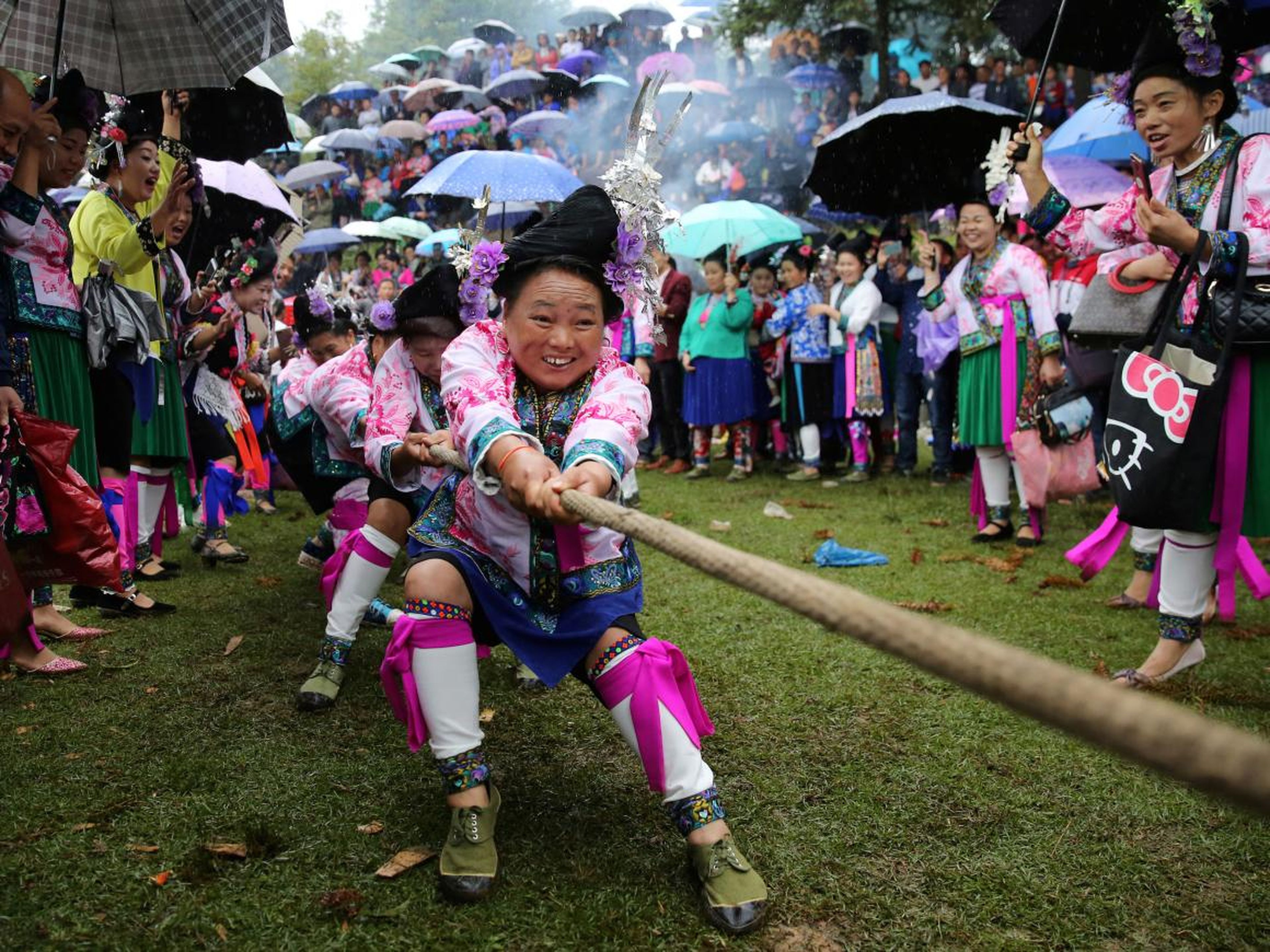 Las mujeres de etnia miao con trajes tradicionales participan en un tira y afloja para celebrar un festival local en una aldea en el condado autónomo Miao de Rongshui, región autónoma de Guangxi Zhuang, China.