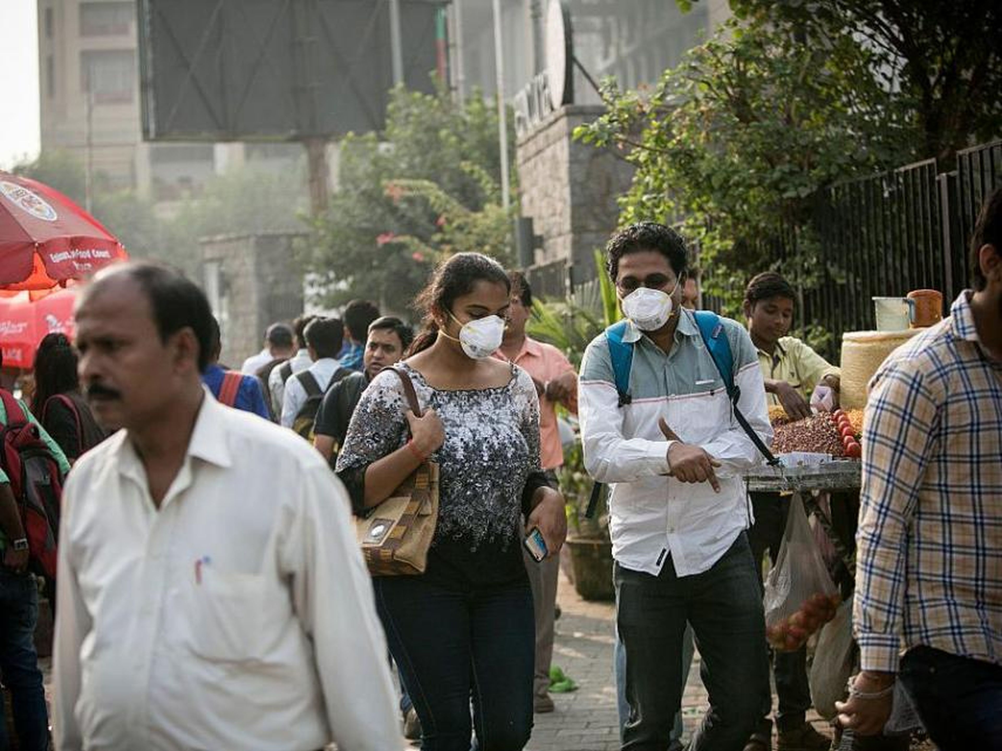 Gente usando máscaras contra la contaminación en medio del polvo y la niebla tóxica en Delhi, India.