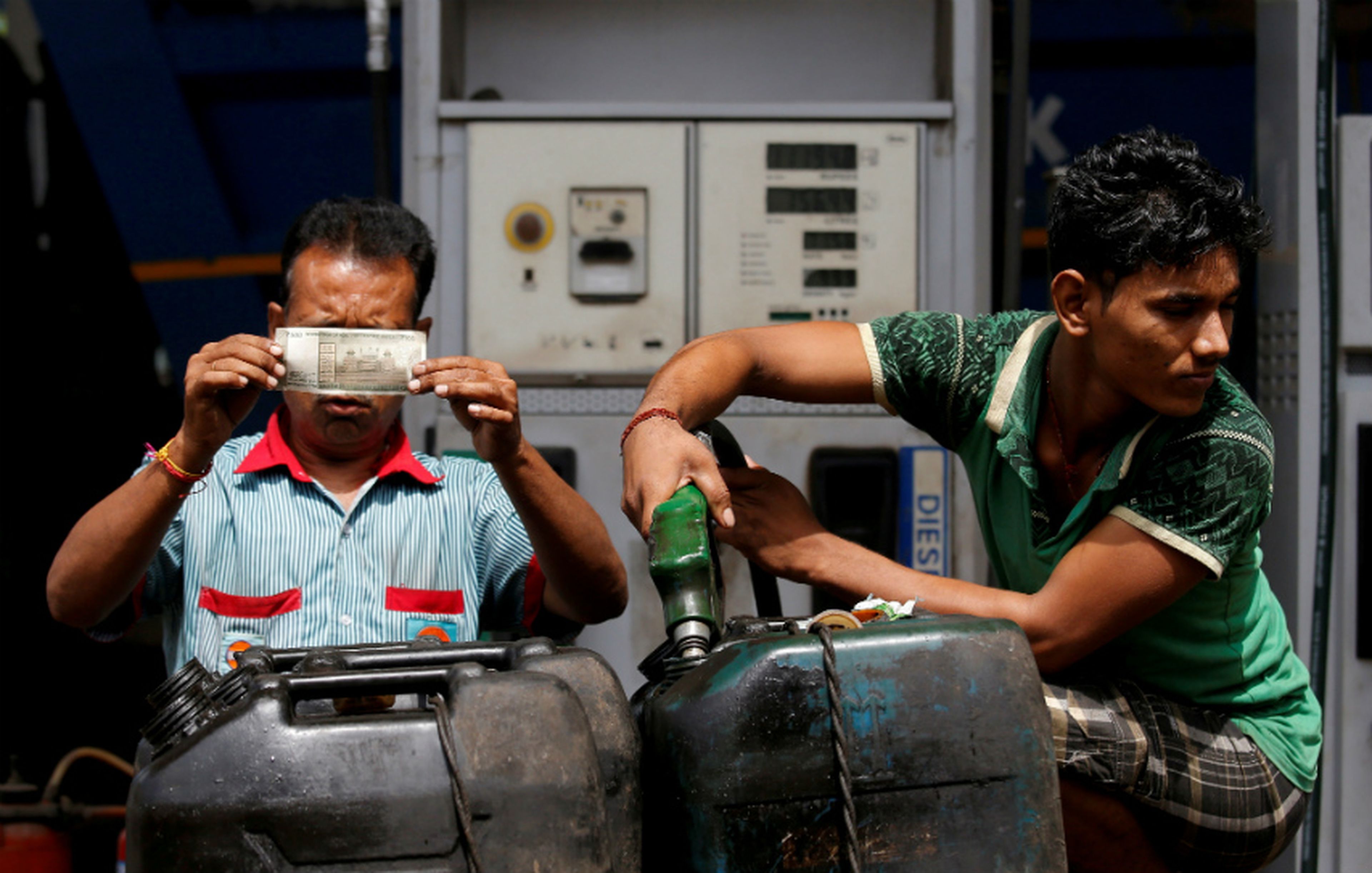 Trabajadores en India observan una rupia