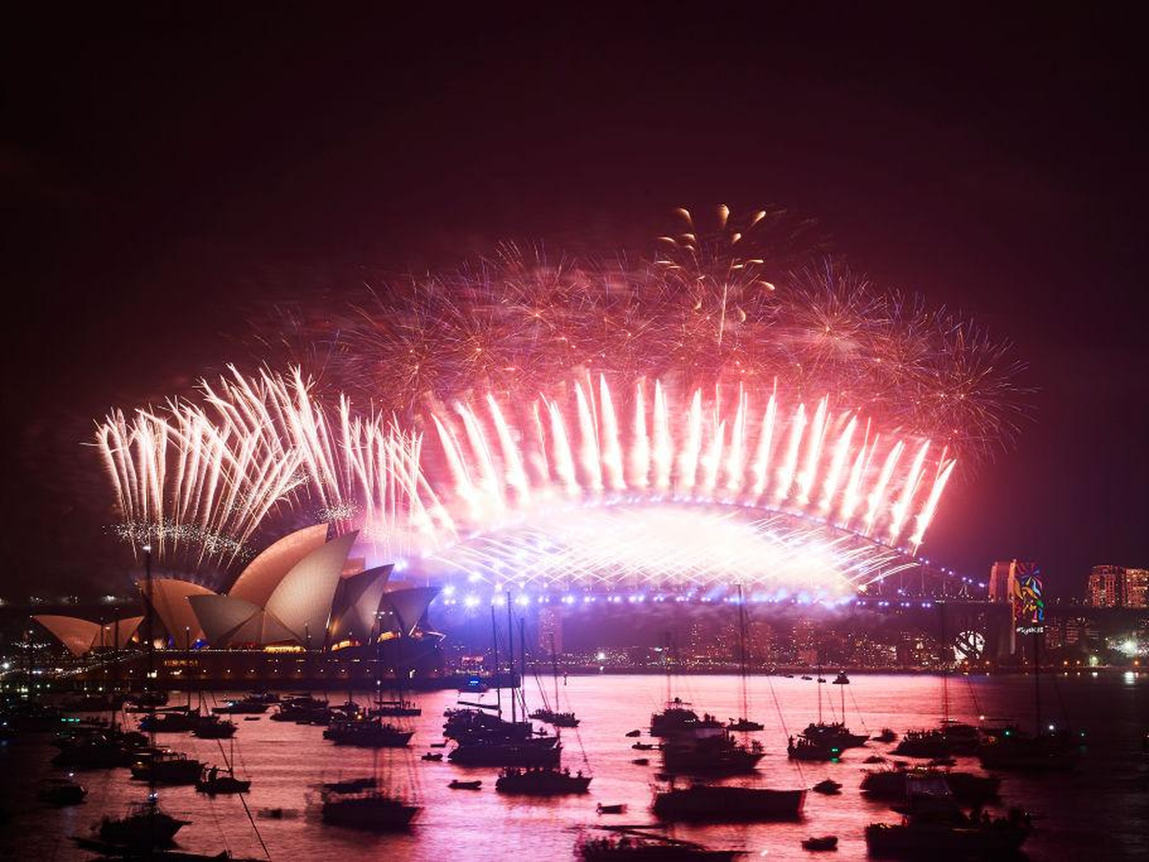 Fuegos artificiales por encima del Puente de la bahía Sídney y la Opera House en año nuevo.