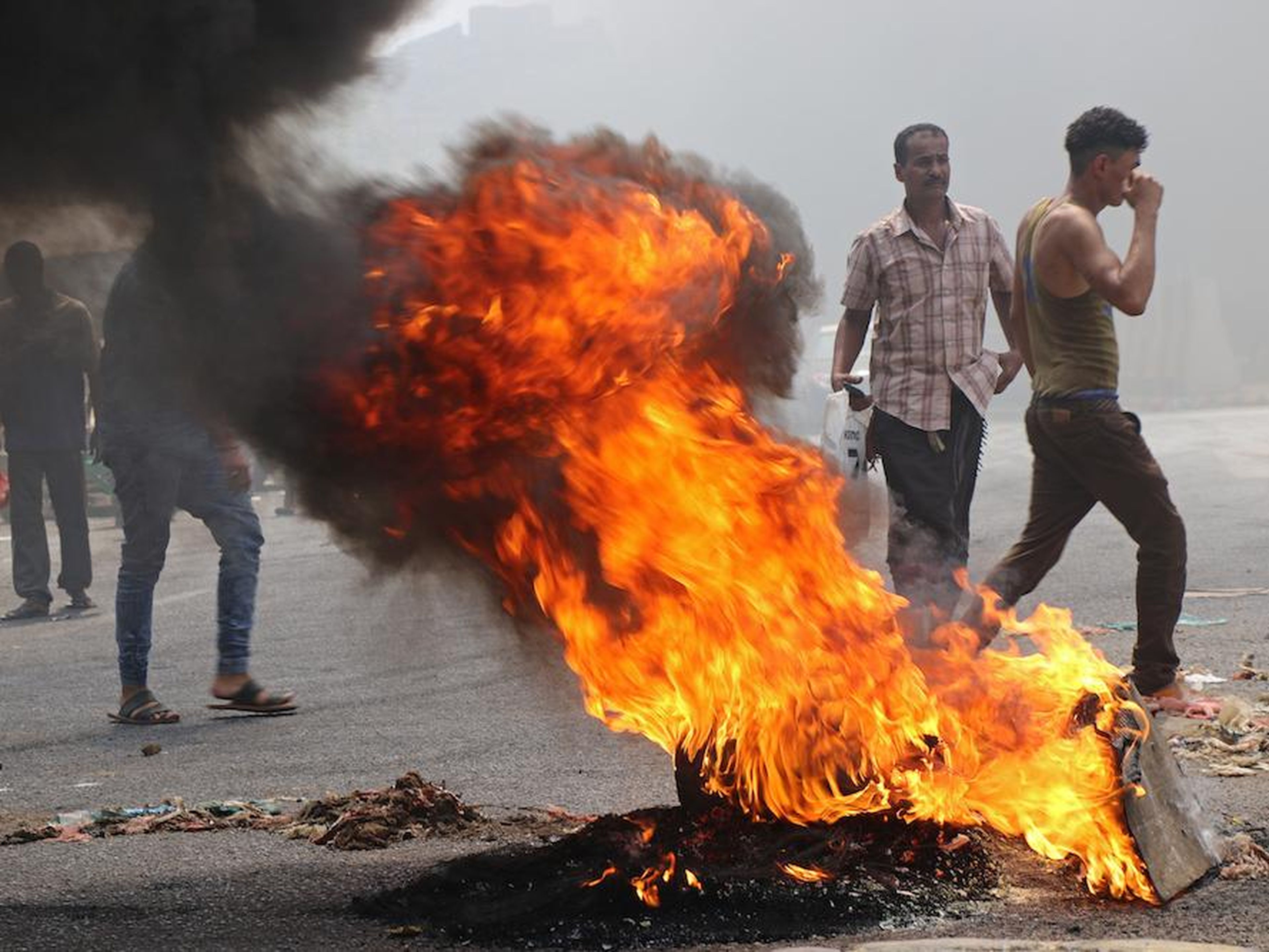 Los manifestantes bloquean una calle con neumáticos en llamas en Aden en septiembre de 2018 después de que la moneda yemení se desplomara.