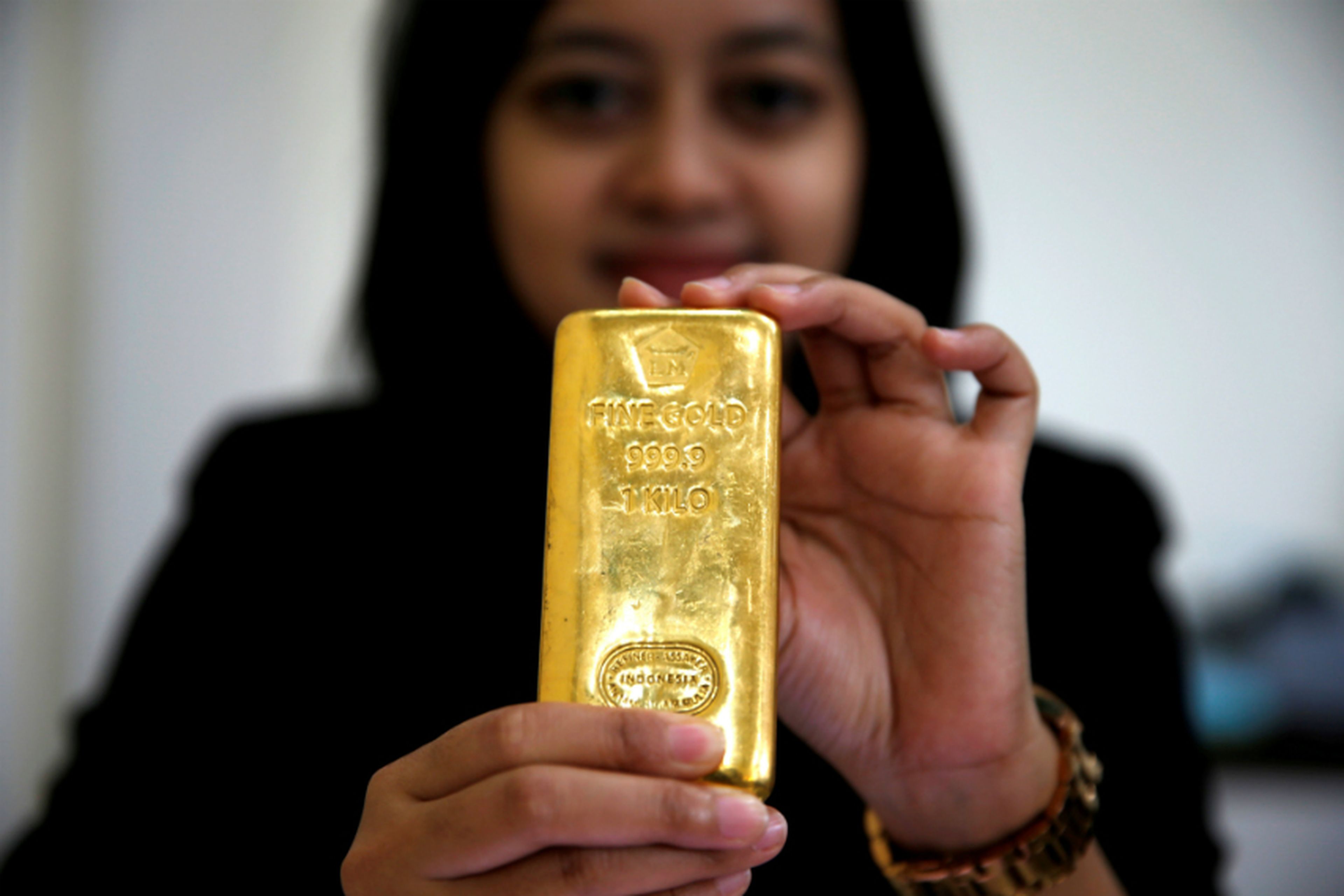 Empleada indonesia con un lingote de oro