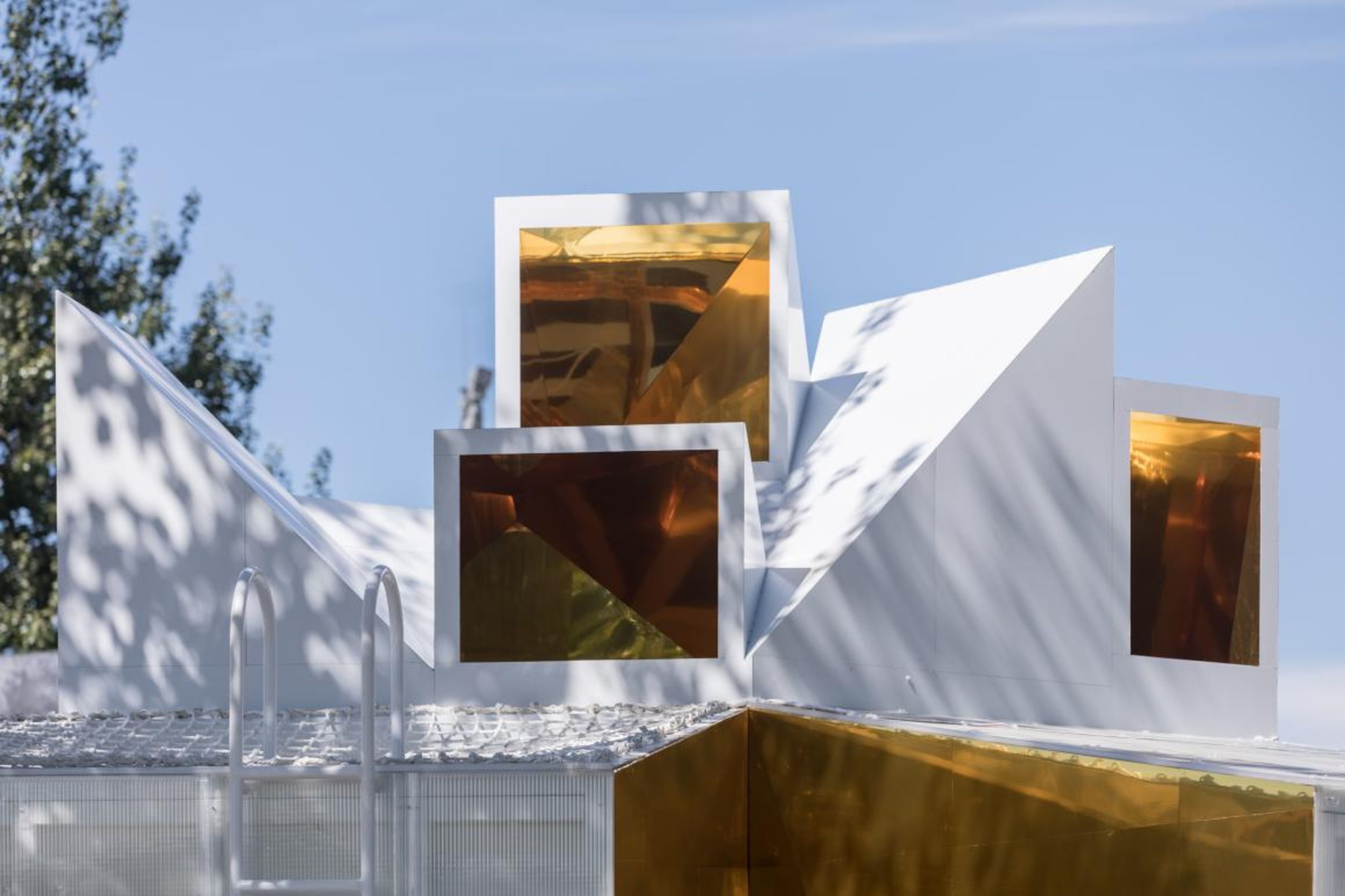 Golden mirrors on the cabin's exterior reflect its urban surroundings.