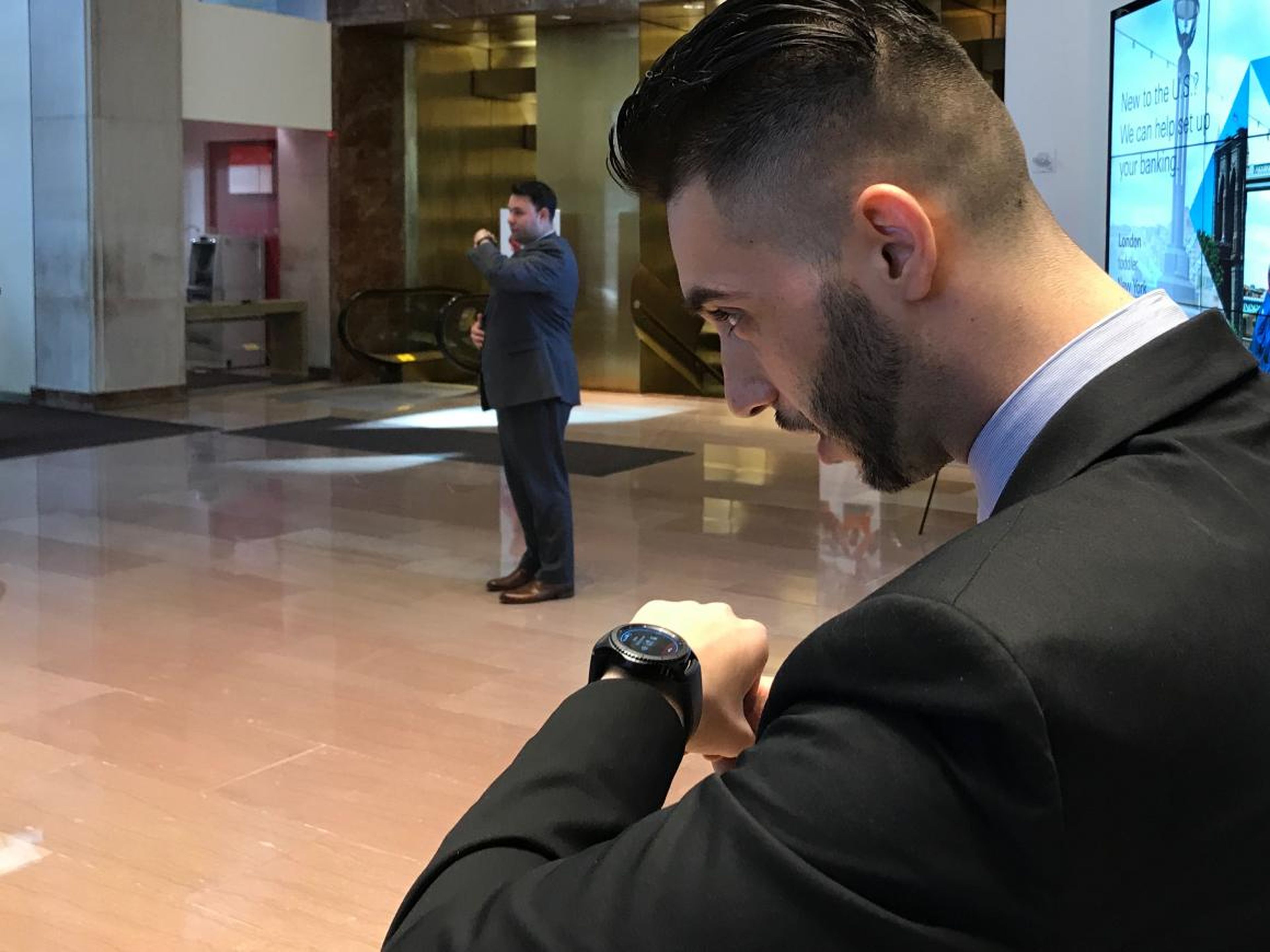 A branch banker uses his phone to speak with a colleague