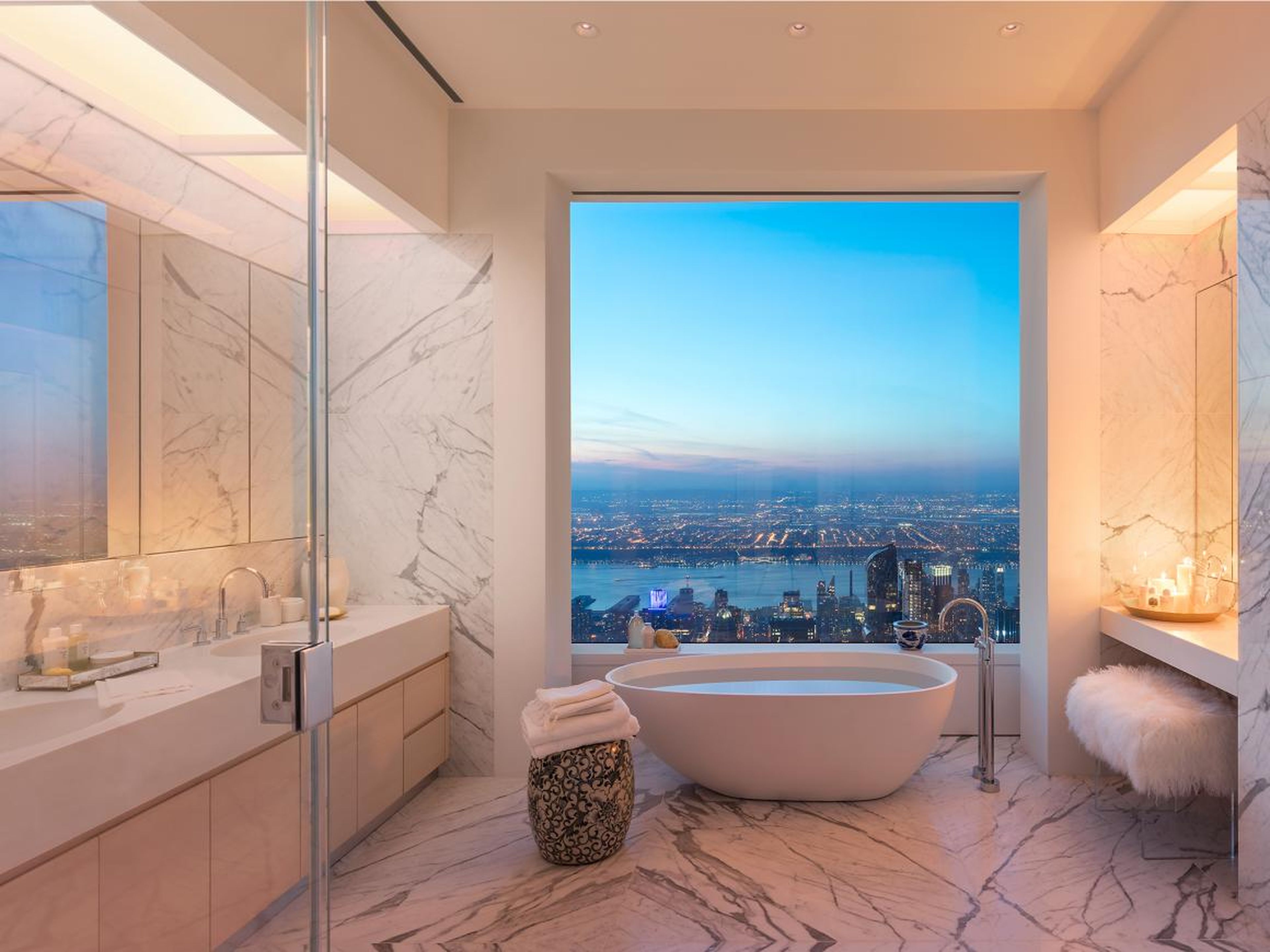 The luxurious master bathroom had marble floors and walls, cubic marble vanities with 22-inch oval sinks, custom wood cabinets, a large freestanding soaking tub, a shower, heated floors — and eye-popping views of the city.