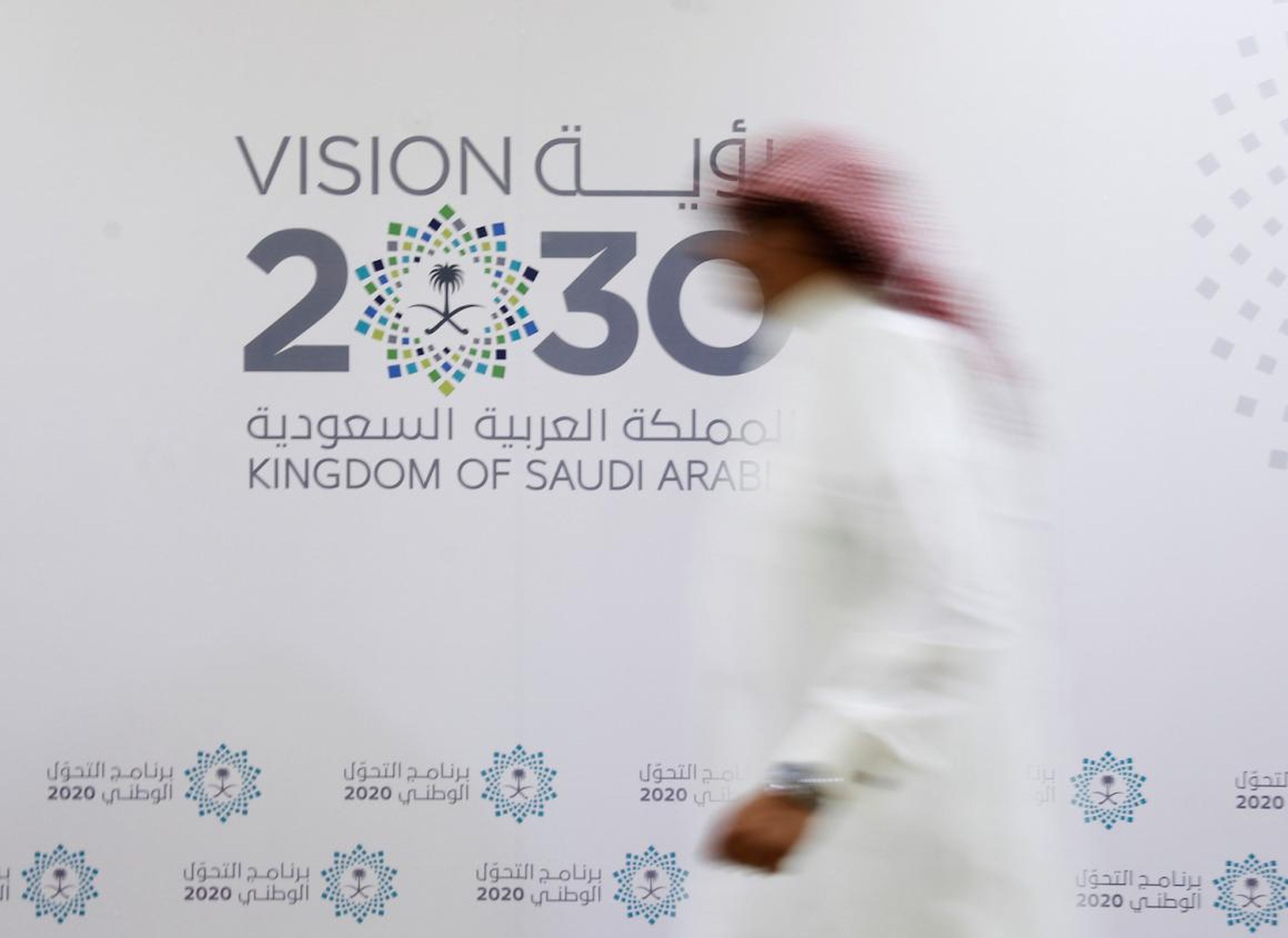 Un hombre saudí pasa junto al logotipo de Visión 2030 después de una conferencia de prensa, en Jeddah, Arabia Saudita, el 7 de junio de 2016.