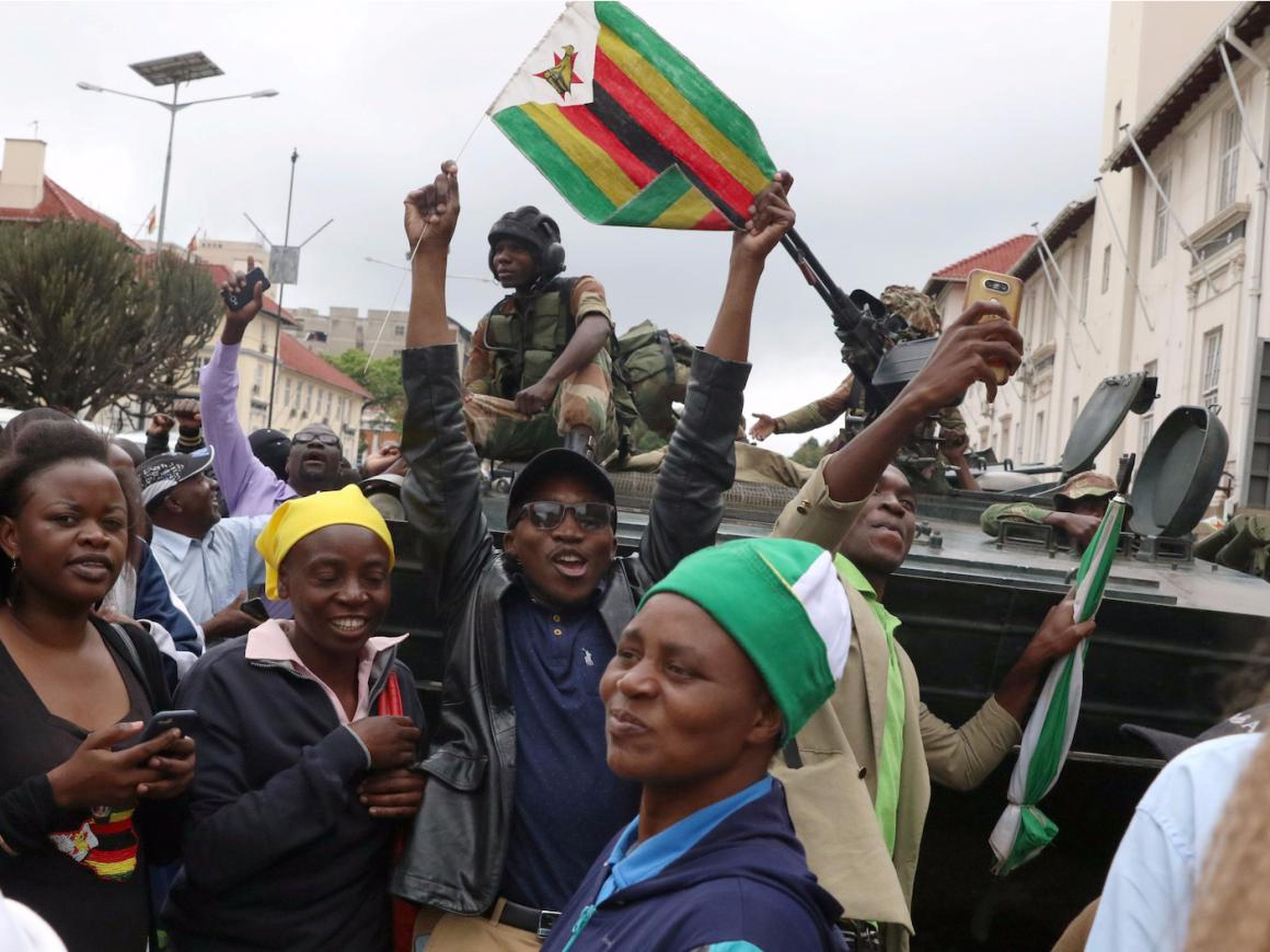 Manifestantes pidiendo al presidente zimbabuense Robert Mugabe que renuncie frente a un vehículo militar en Harare, en noviembre de 2017.