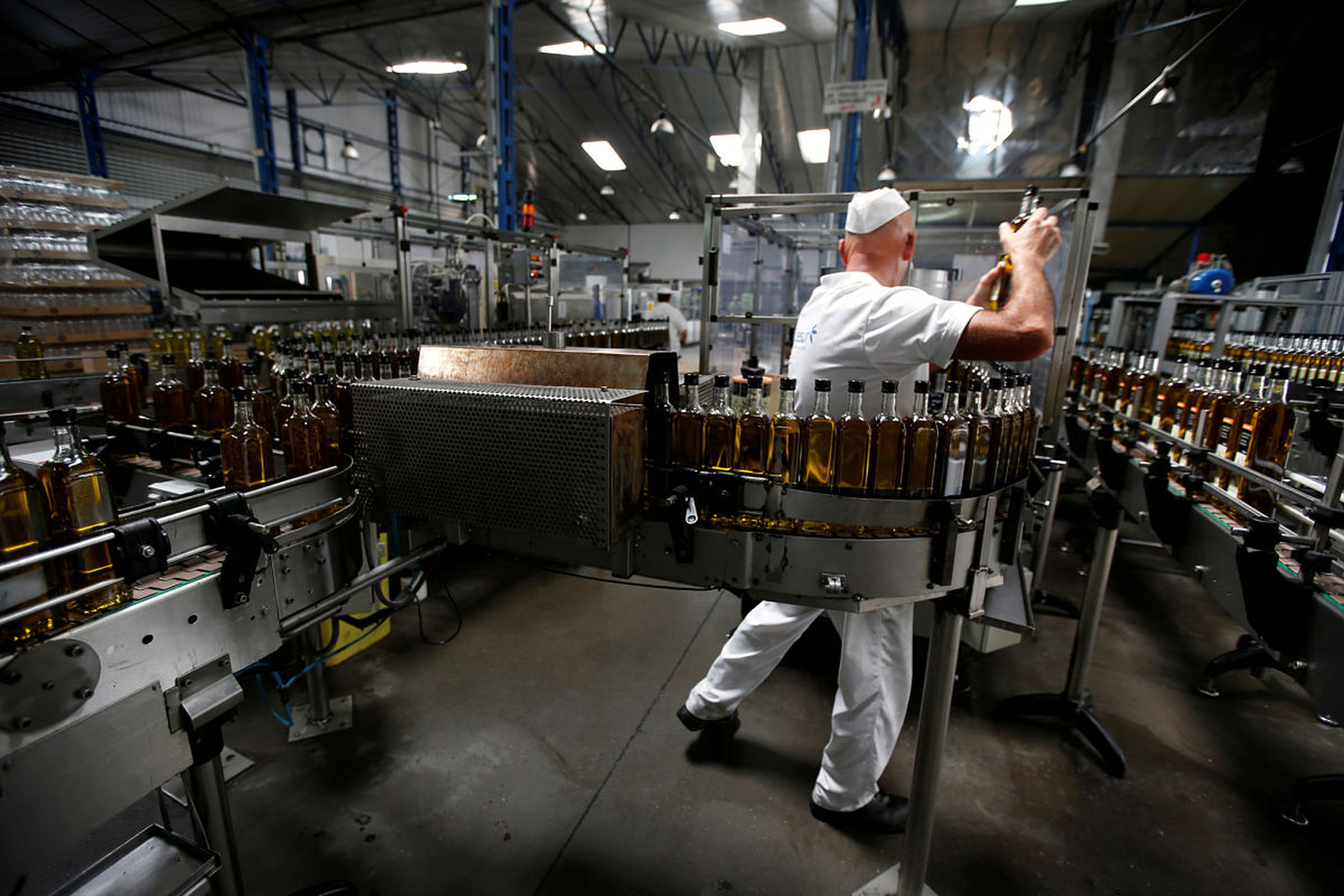 Un trabajador revisa una línea de embotellado de aceite de oliva en una planta de Dos Hermanas (Sevilla)