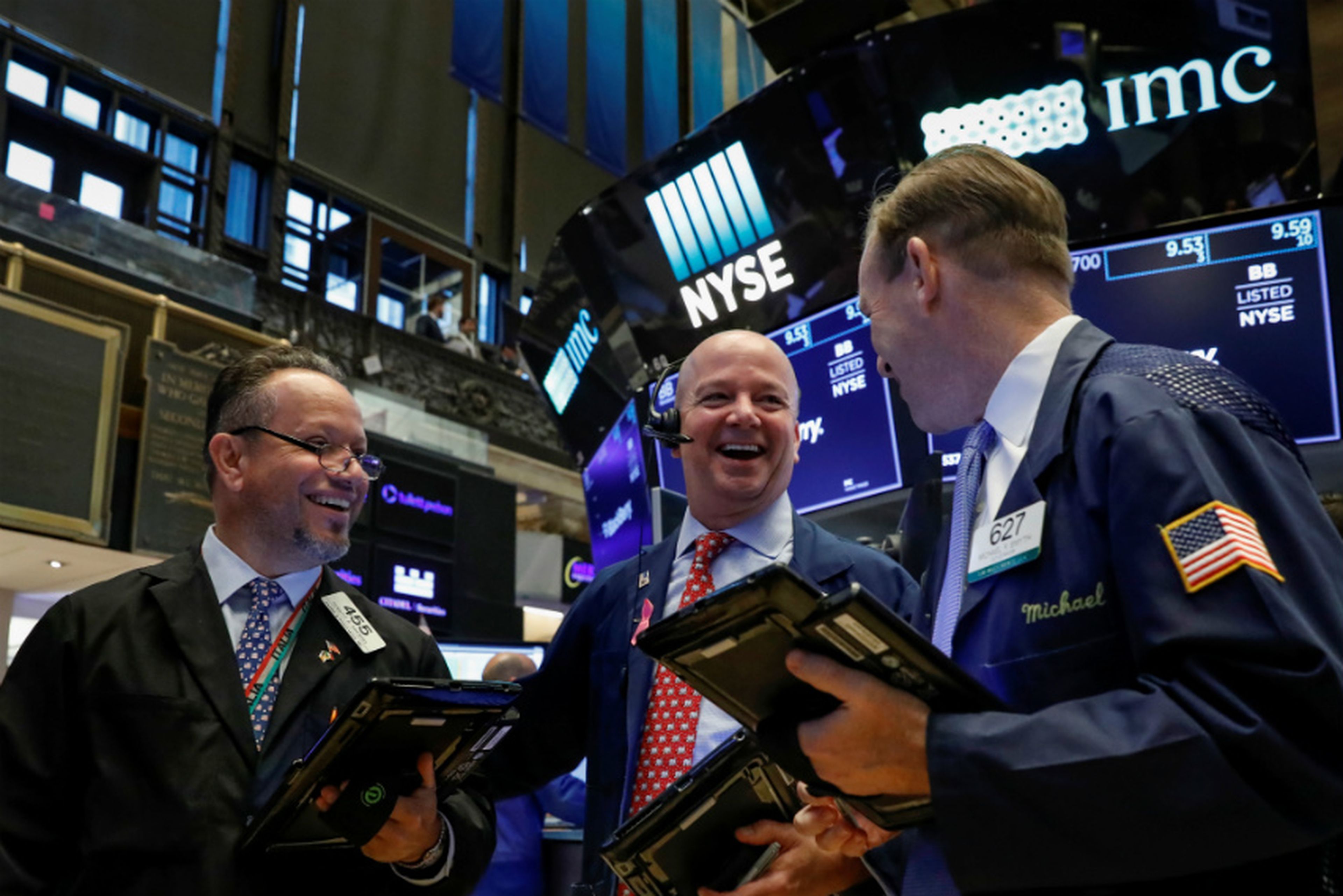 Traders sonrien operando en Wall Street
