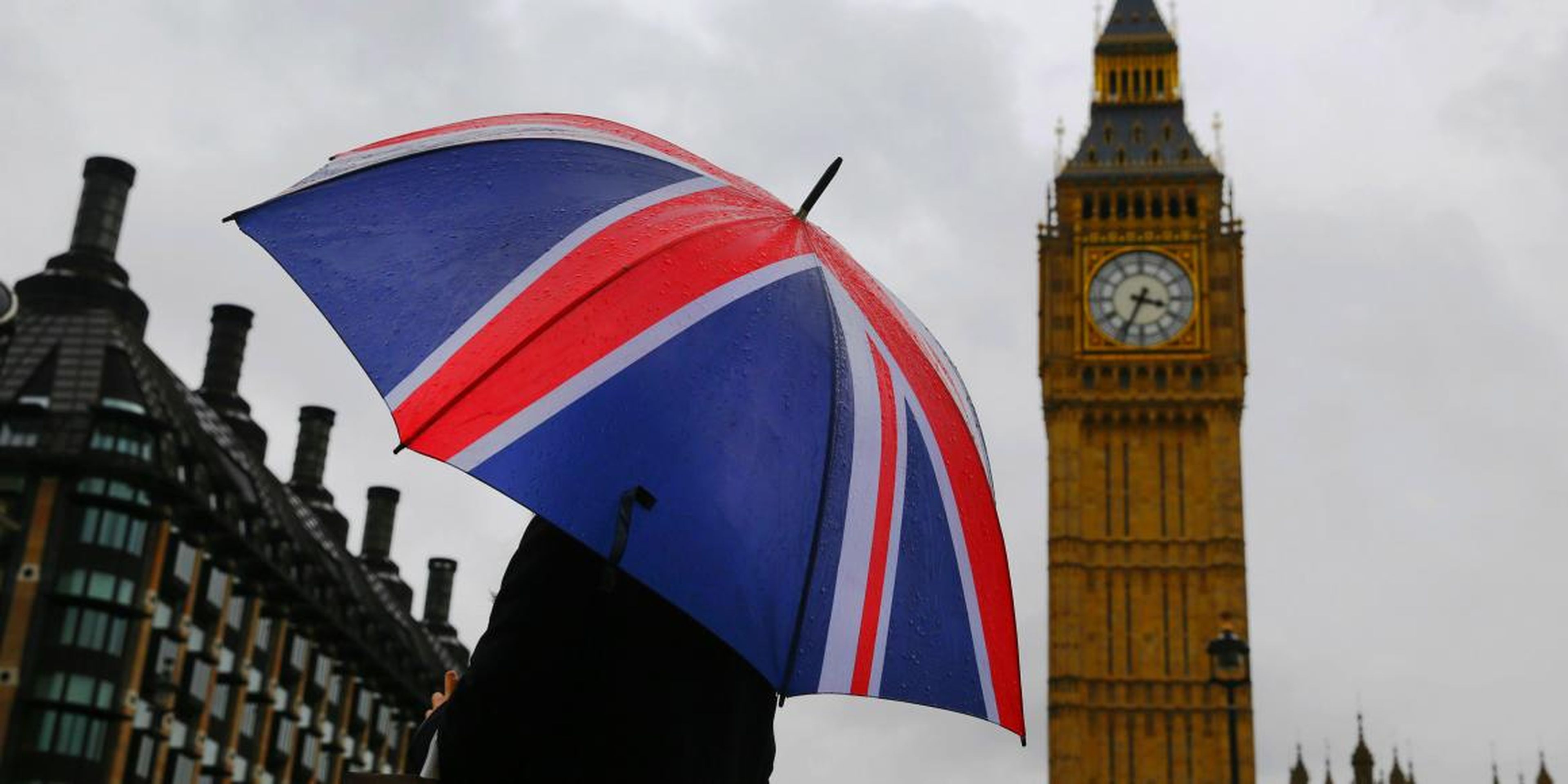 Una mujer lleva un paraguas con la bandera de Reino Unido frente a la torre del Big Ben en Londres, el 4 de octubre de 2014.