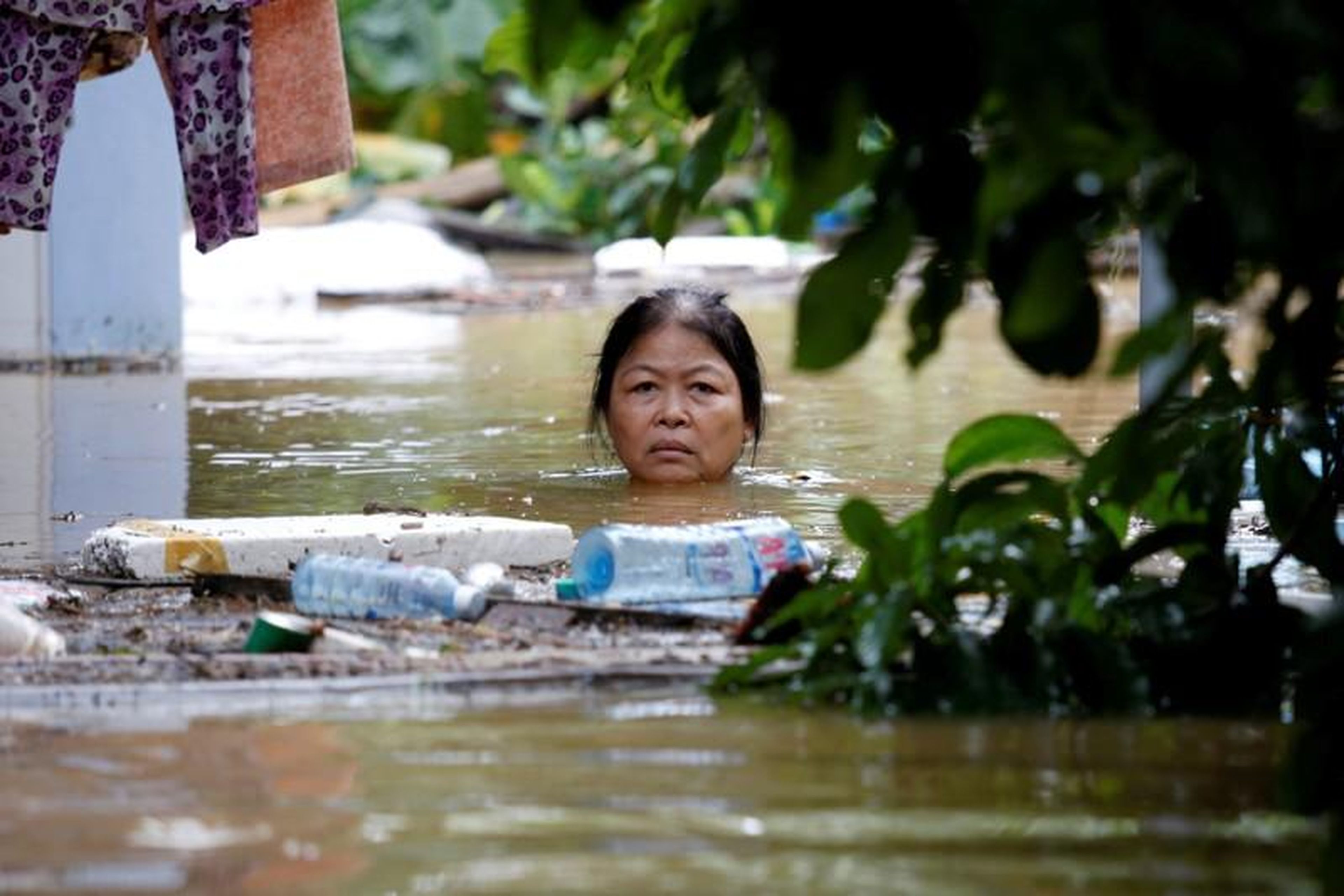 A woman wades through a submerged street at the UNESCO heritage ancient town of Hoi An after typhoon Damrey hit Vietnam in 2017.