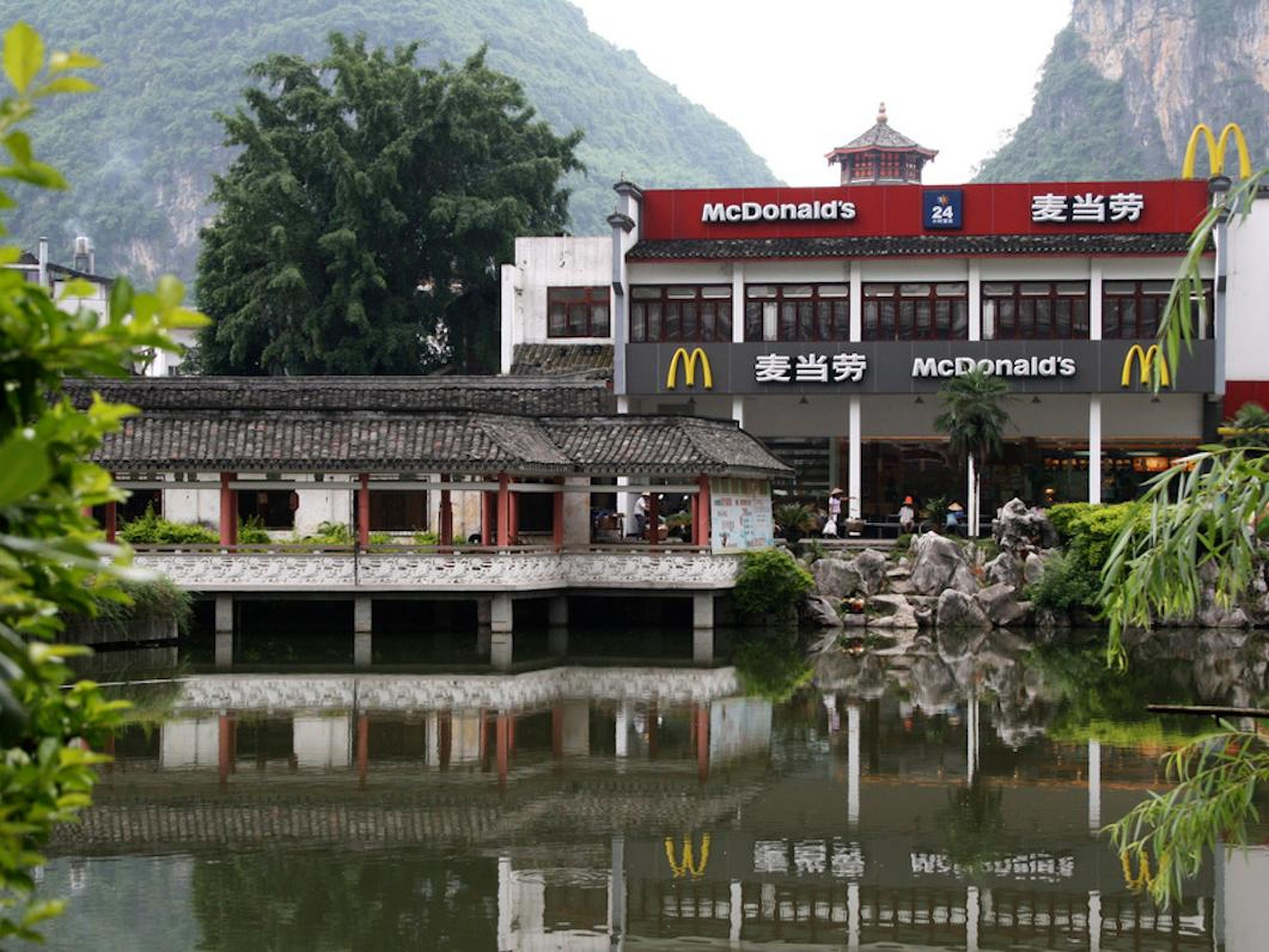 In Yangshuo, China, a McDonald's sits in a pagoda at the base of mountains and has beautiful water views.