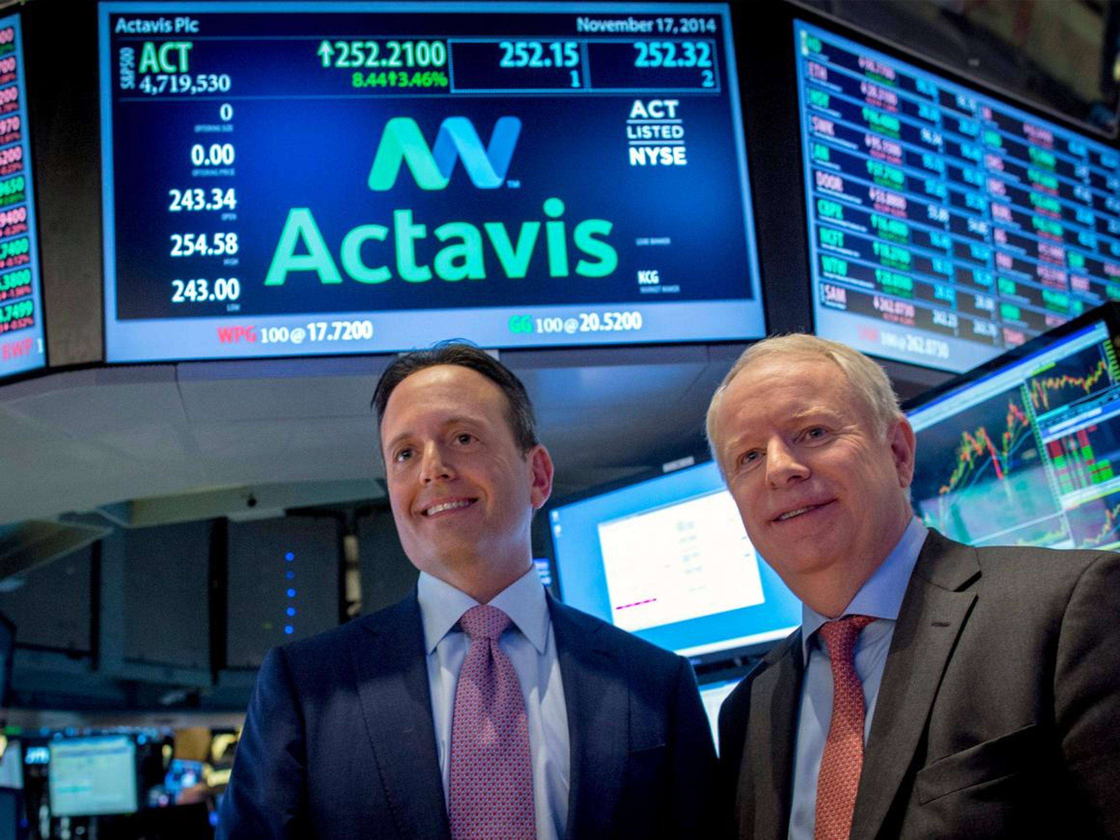 Current Allergan CEO Brent Saunders (left) and former Allergan CEO David Pyott pose together on the floor of the New York Stock Exchange November 17, 2014.
