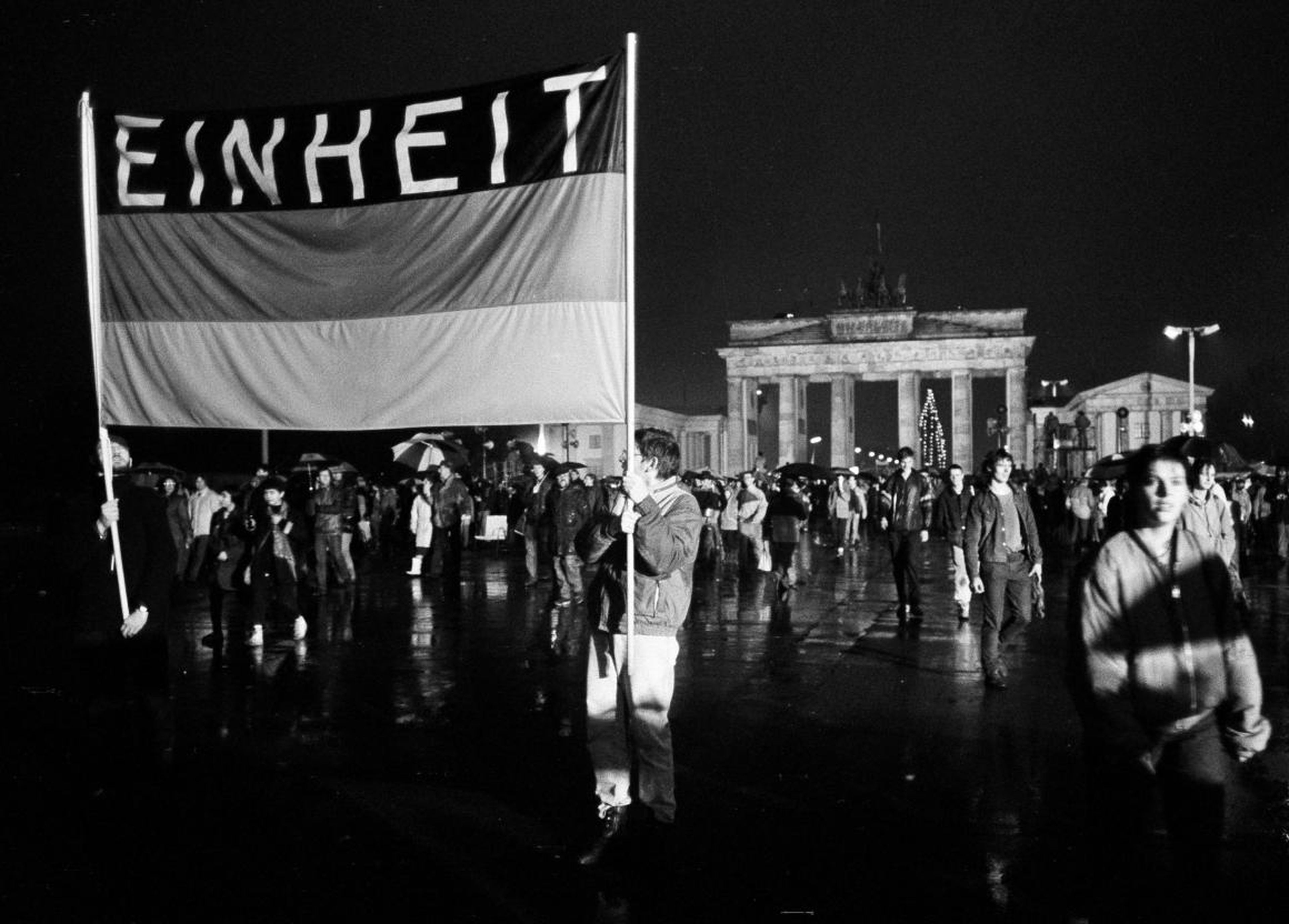 This flag reading "Unity" was waved high as these Germans crossed the newly opened border December 22.