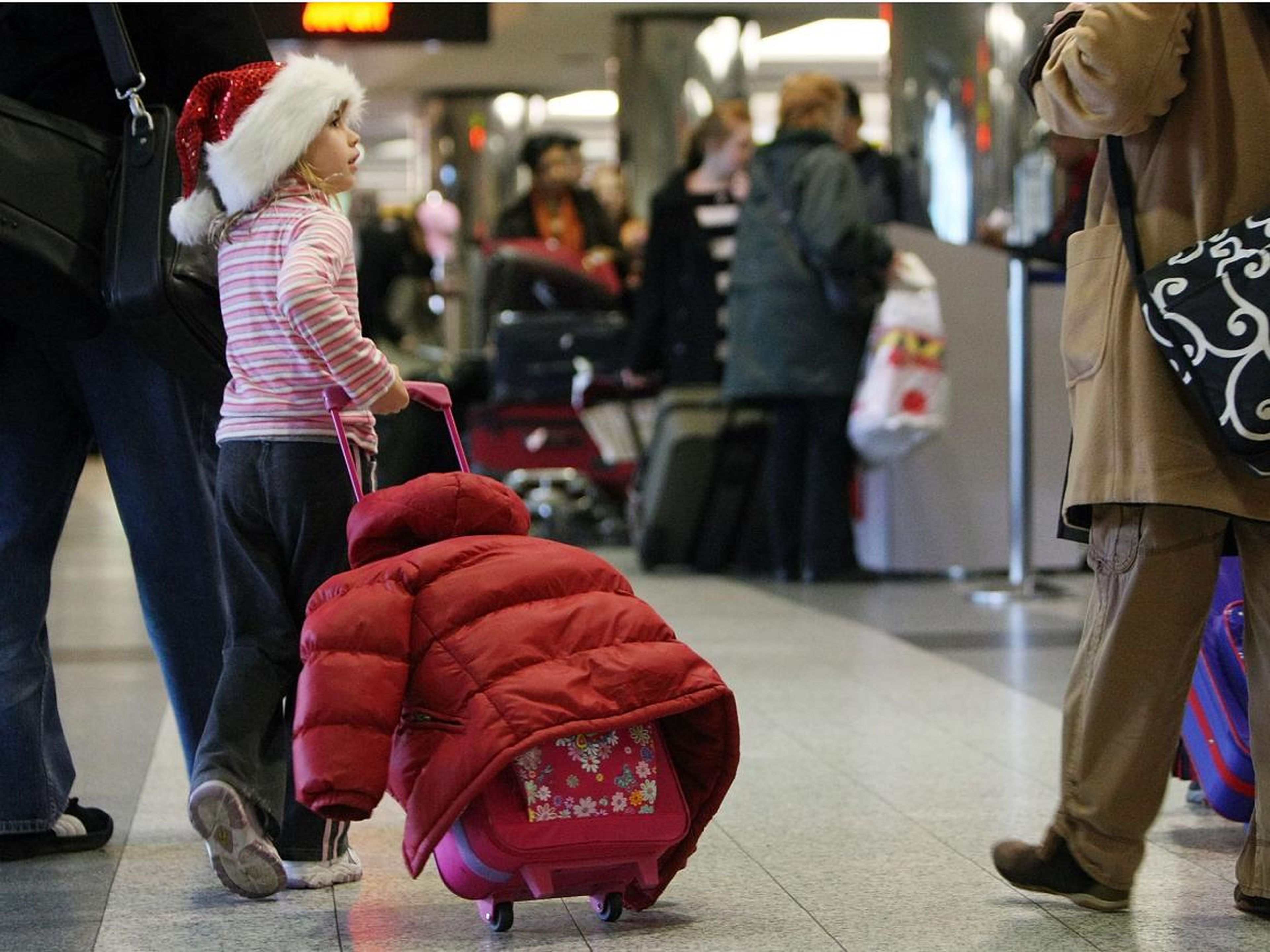 A girl traveling in a Santa hat.