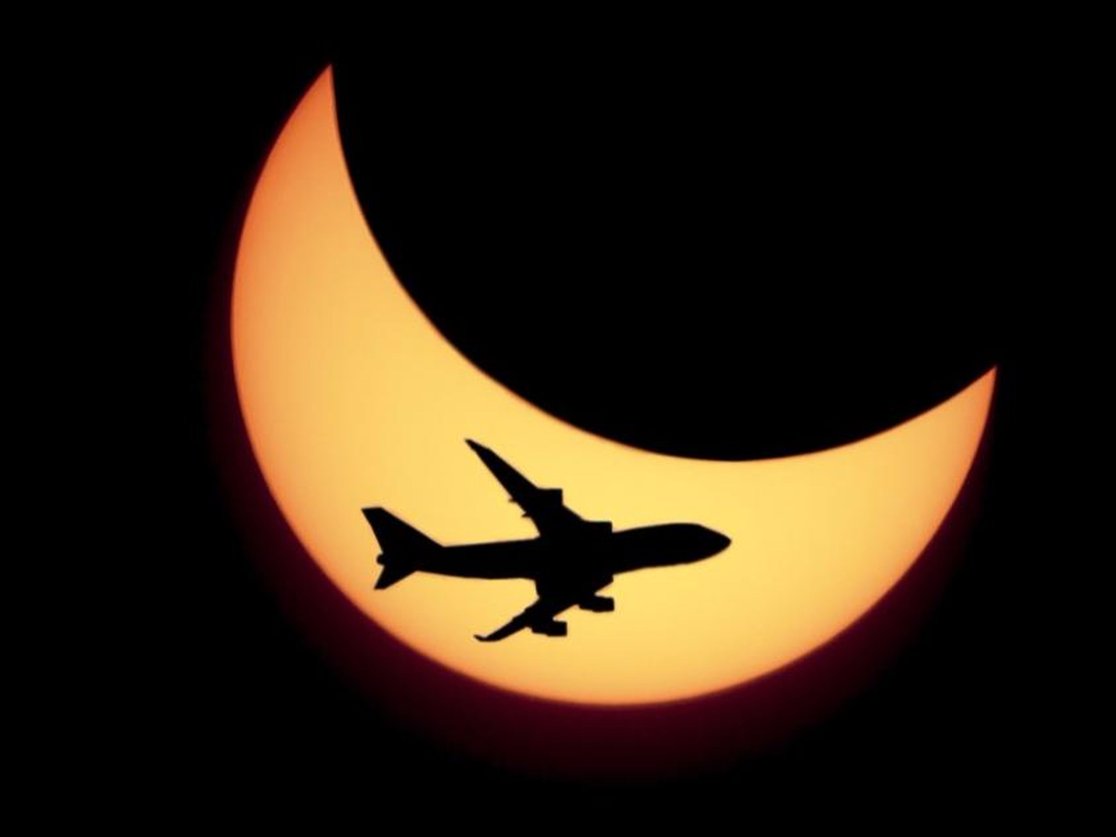 Un avión sobrevuela un eclipse solar.