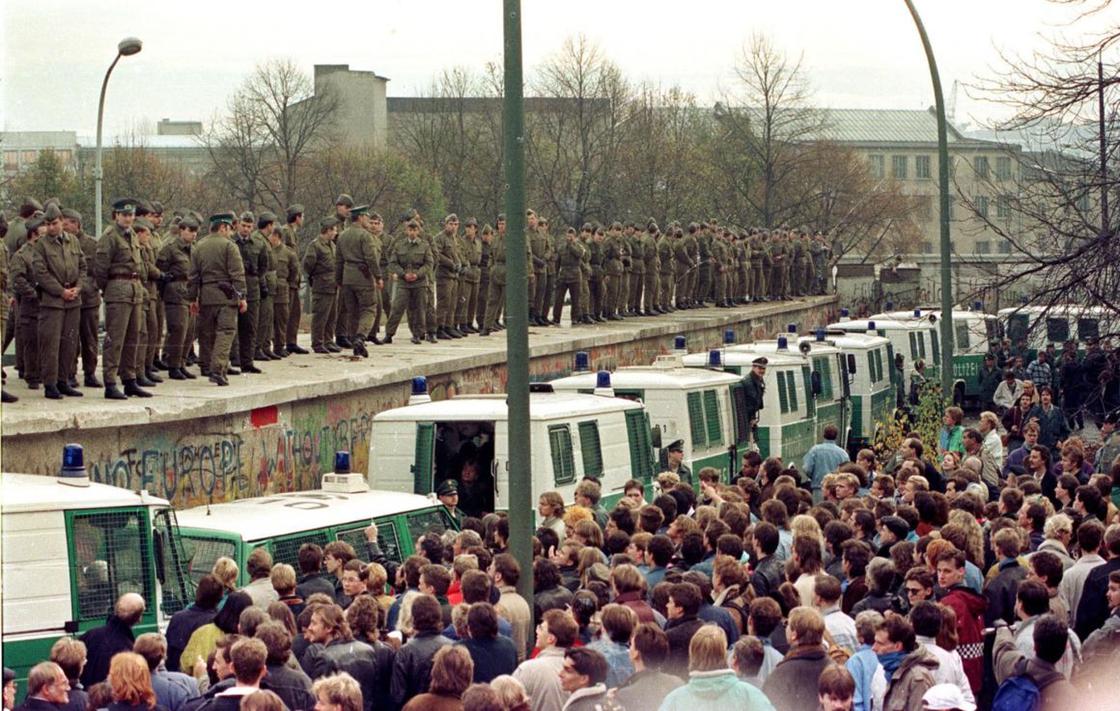 Looking out onto a sea of thousands, East Berlin border guards stood atop the Berlin Wall at the Brandenburg Gate November 11.