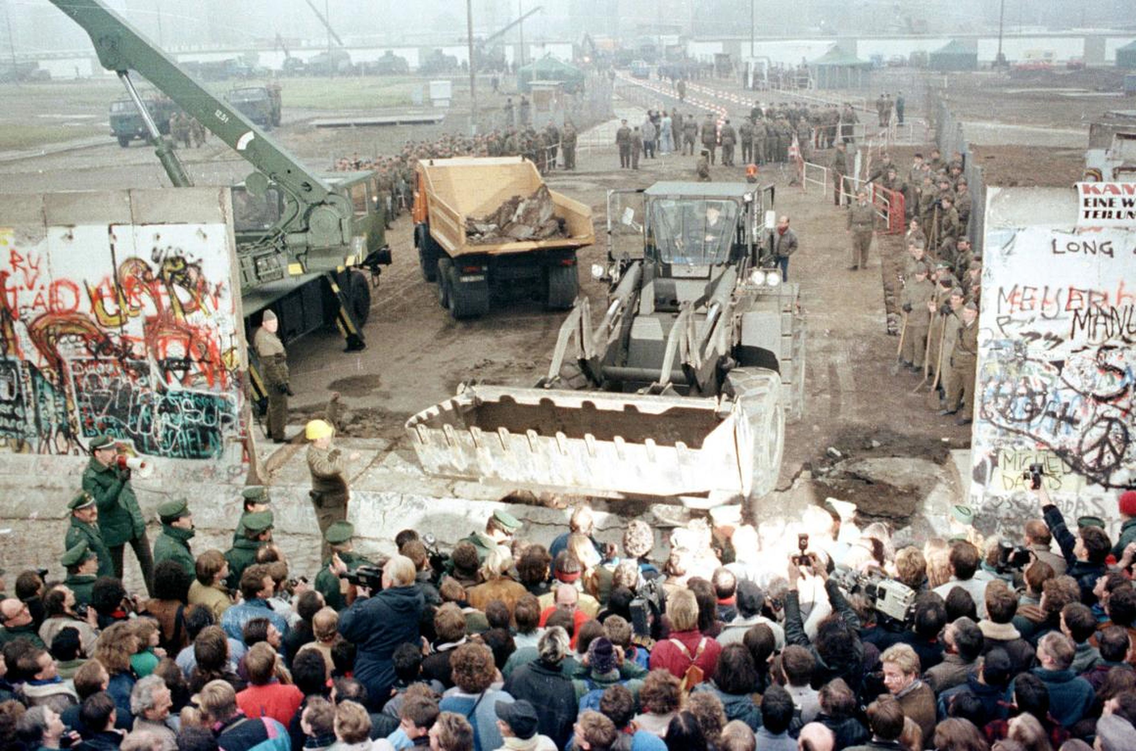By November 12, it was no longer only small hammers being used to deconstruct the wall. Here, an East German bulldozer and crane knock down the Berlin Wall at Potsdamer Platz.