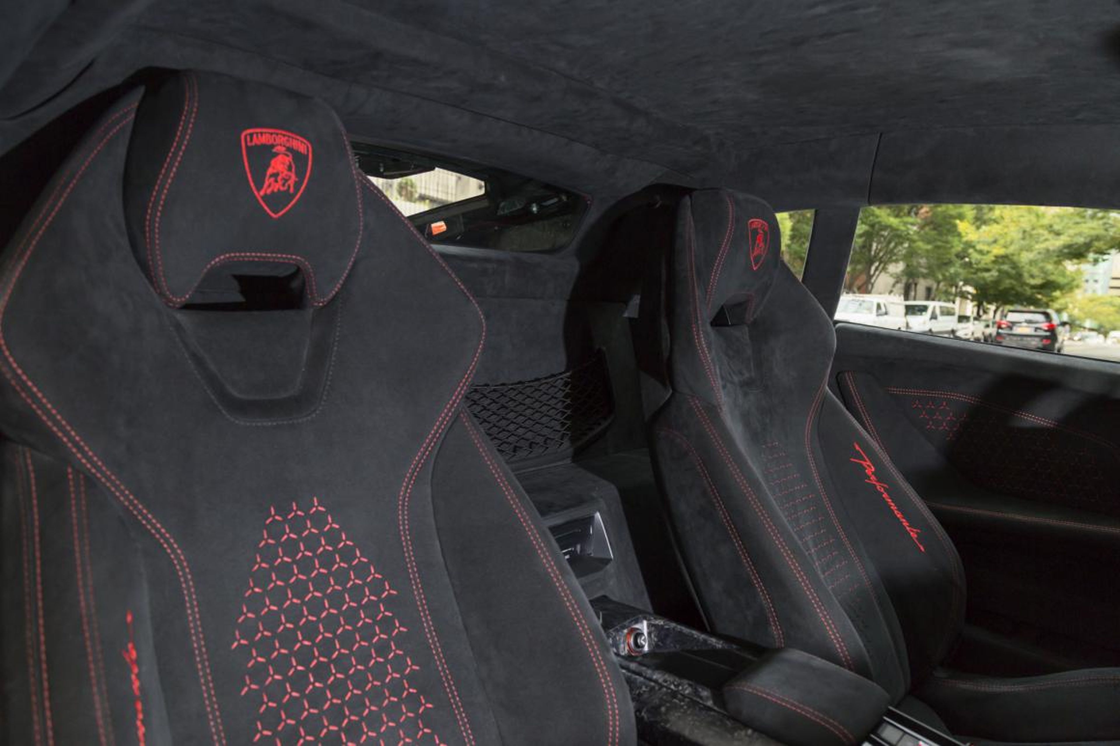 The red Lambo badging and stitching adds some flash to the otherwise monotonous "Nero Cosmus" interior.