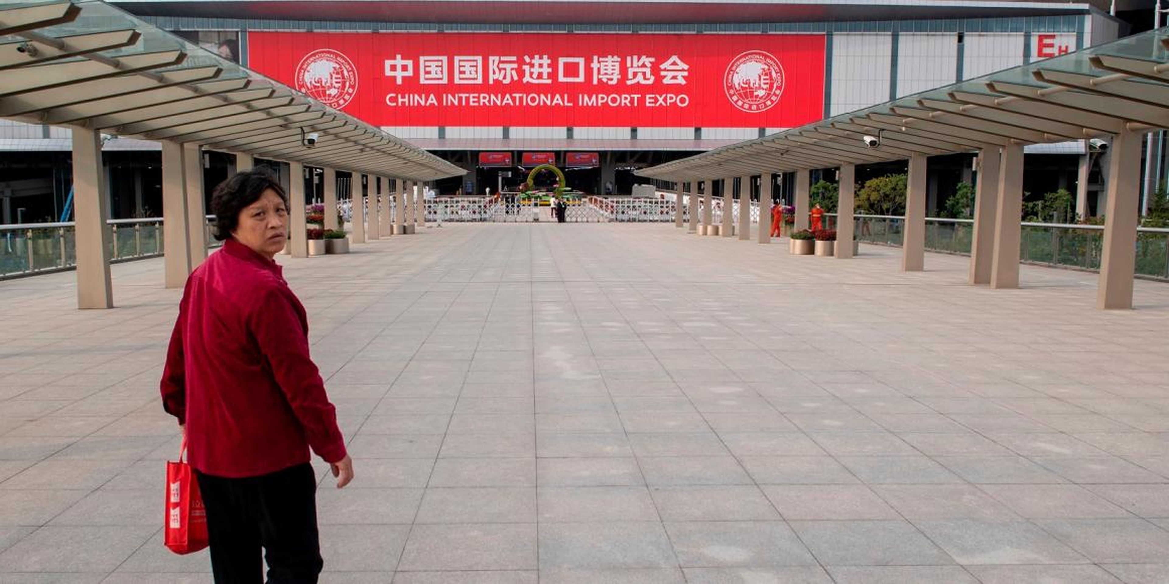 A woman walks towards the entrance of the National Exhibition and Convention Center (Shanghai), the main venue to hold the upcoming first China International Import Expo (CIIE), in Shanghai on October 31, 2018. - As China seeks to counter charges that its