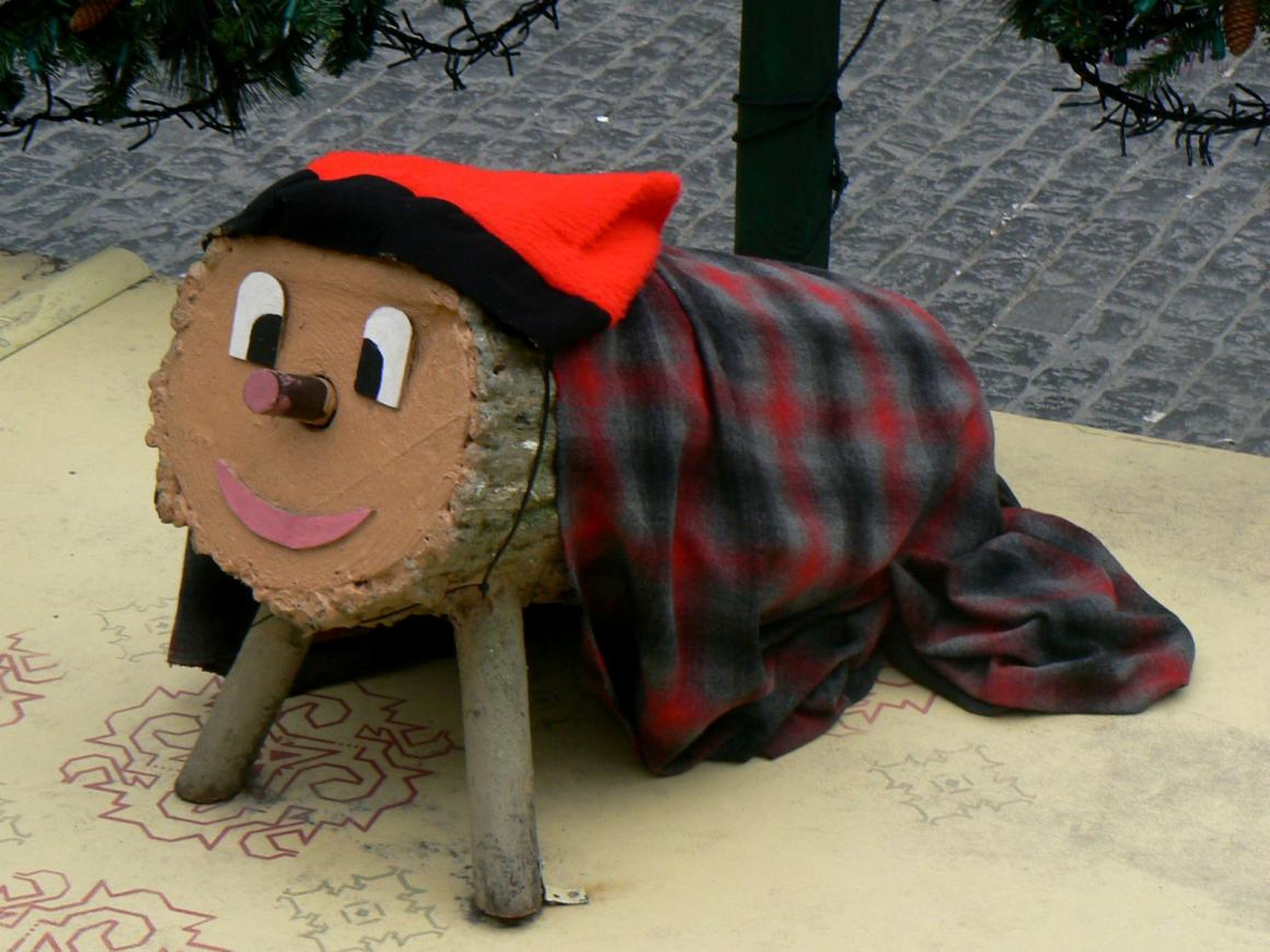 A Tió de Nadal figurine under a Christmas tree in Catalonian Spain.