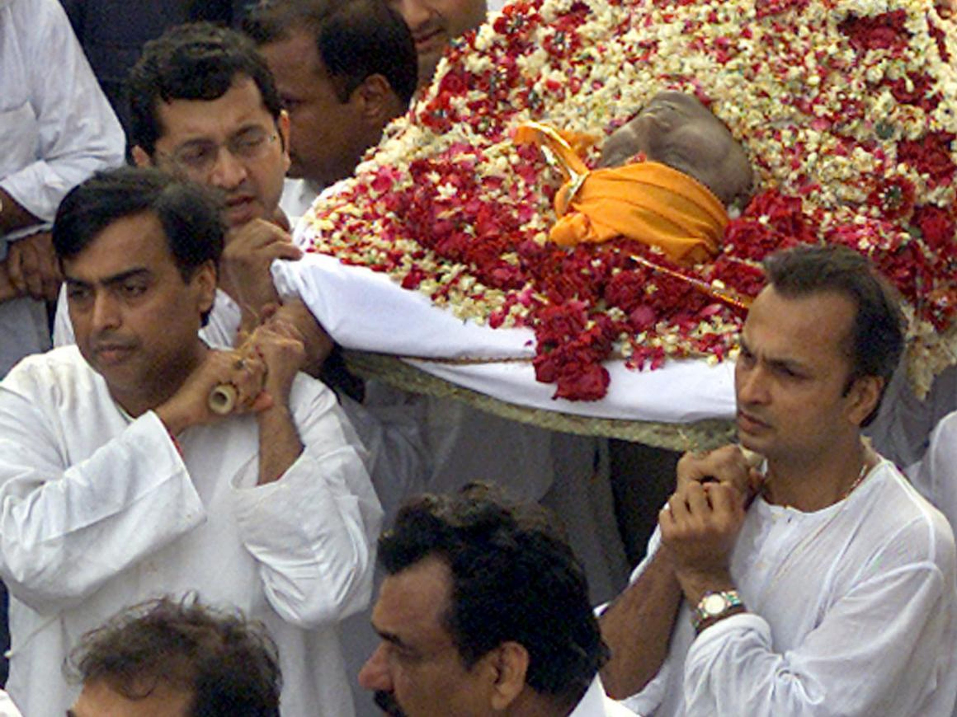 Mukesh Ambani, left, and Anil Ambani, right, carry their father's body to a crematorium in Bombay on July 7, 2002, a day after his death.