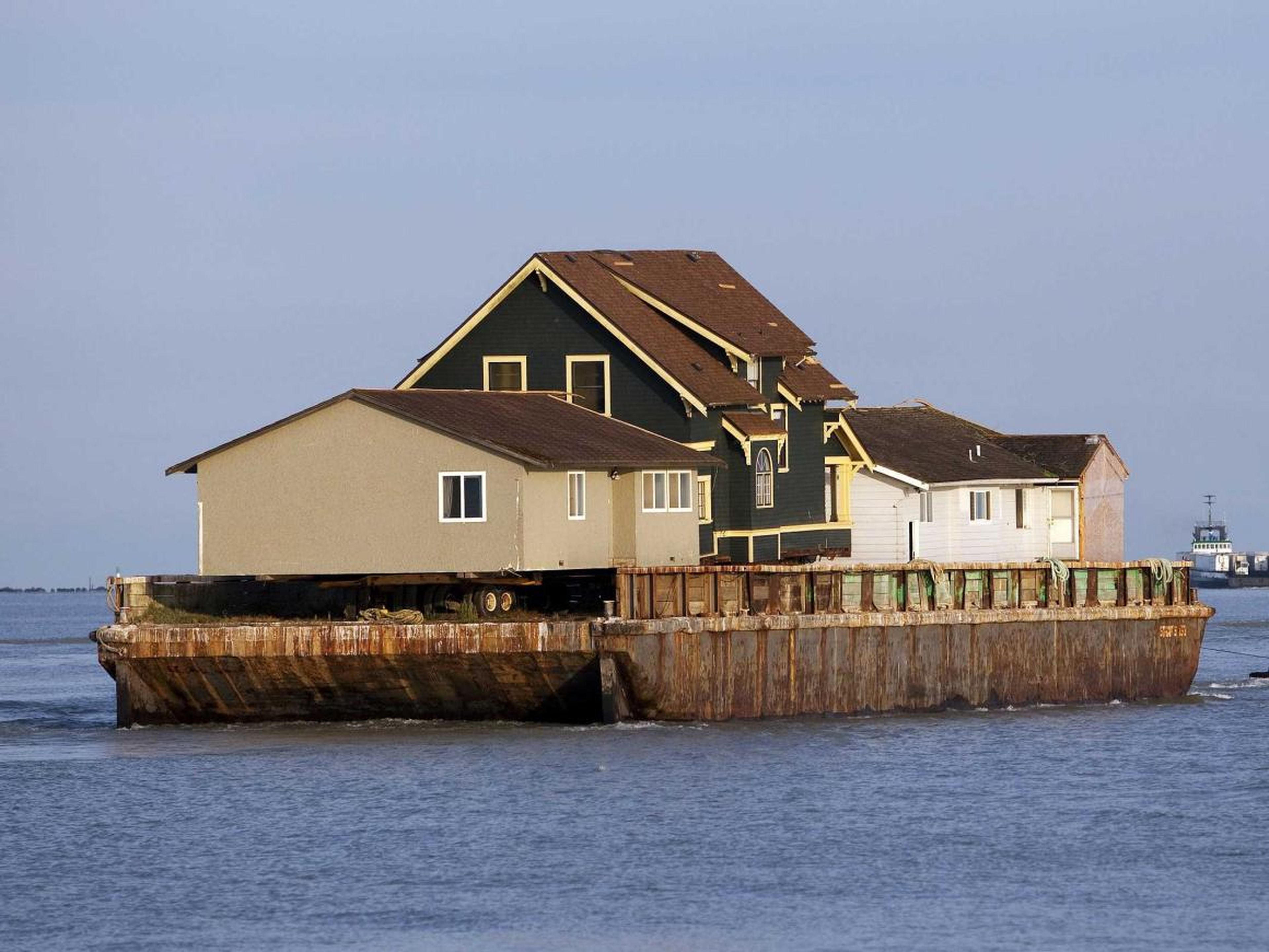 Una barcaza con tres casas es arrastrada hacia el estrecho de Georgia cerca de Richmond, Columbia Británica, el 1 de agosto de 2012.
