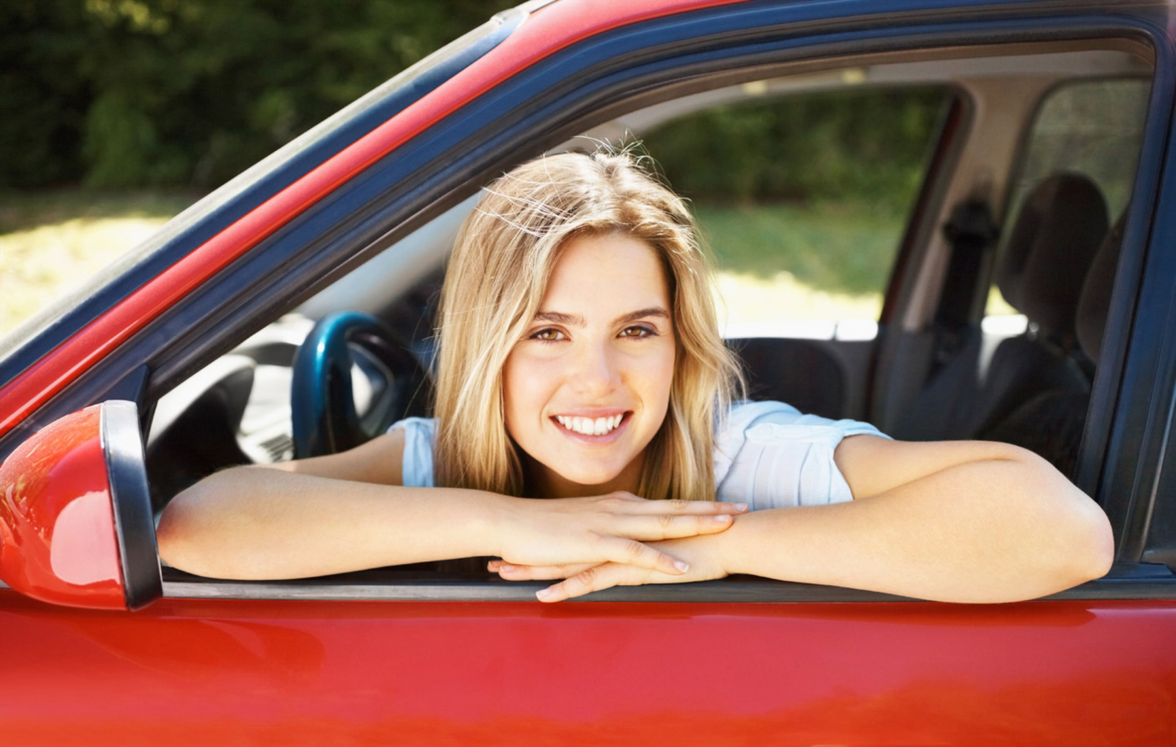 Una mujer joven sentada en el asiento delantero de un coche