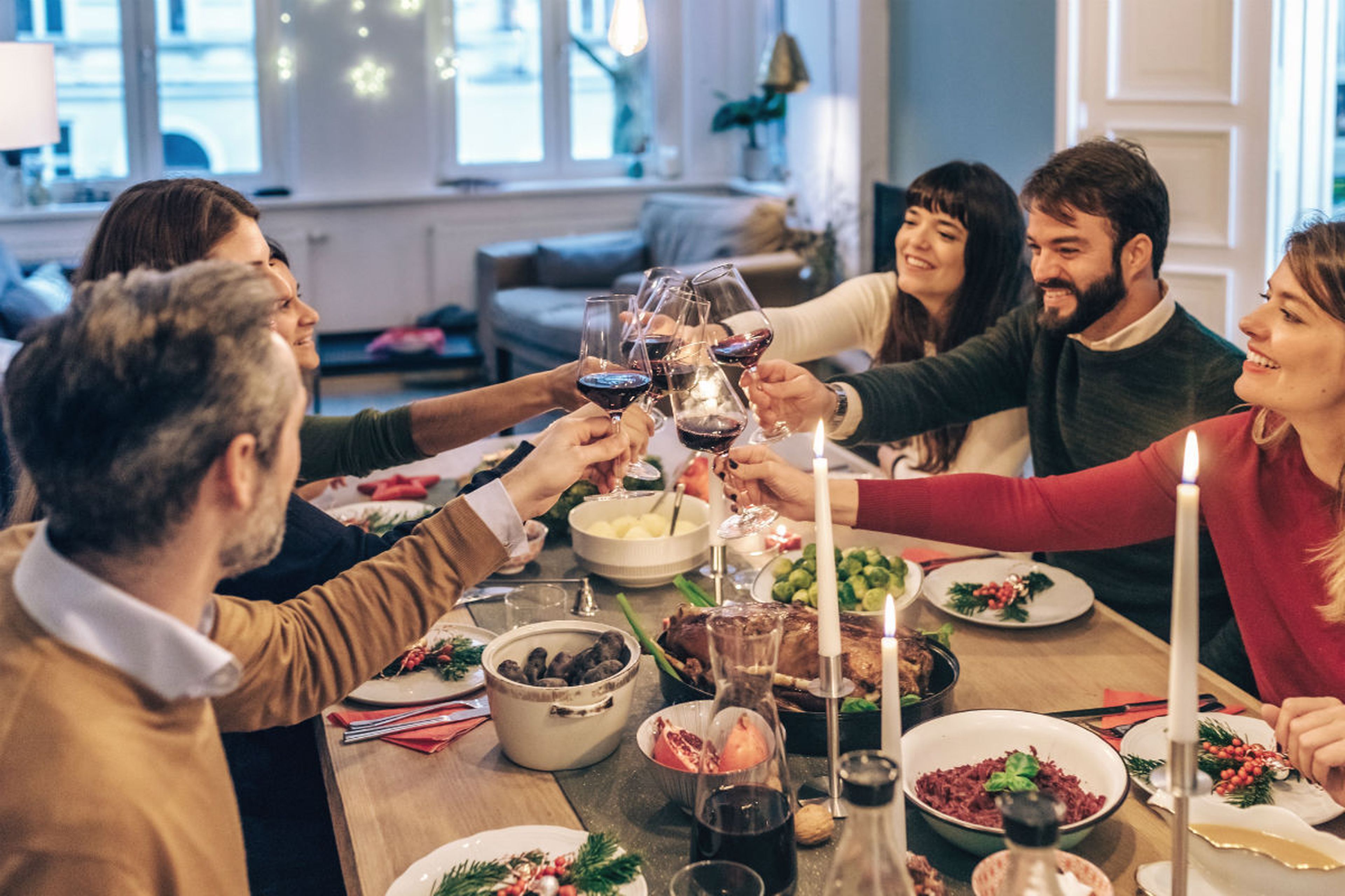 Personas chocan sus copas de vino durante una cena de Navidad