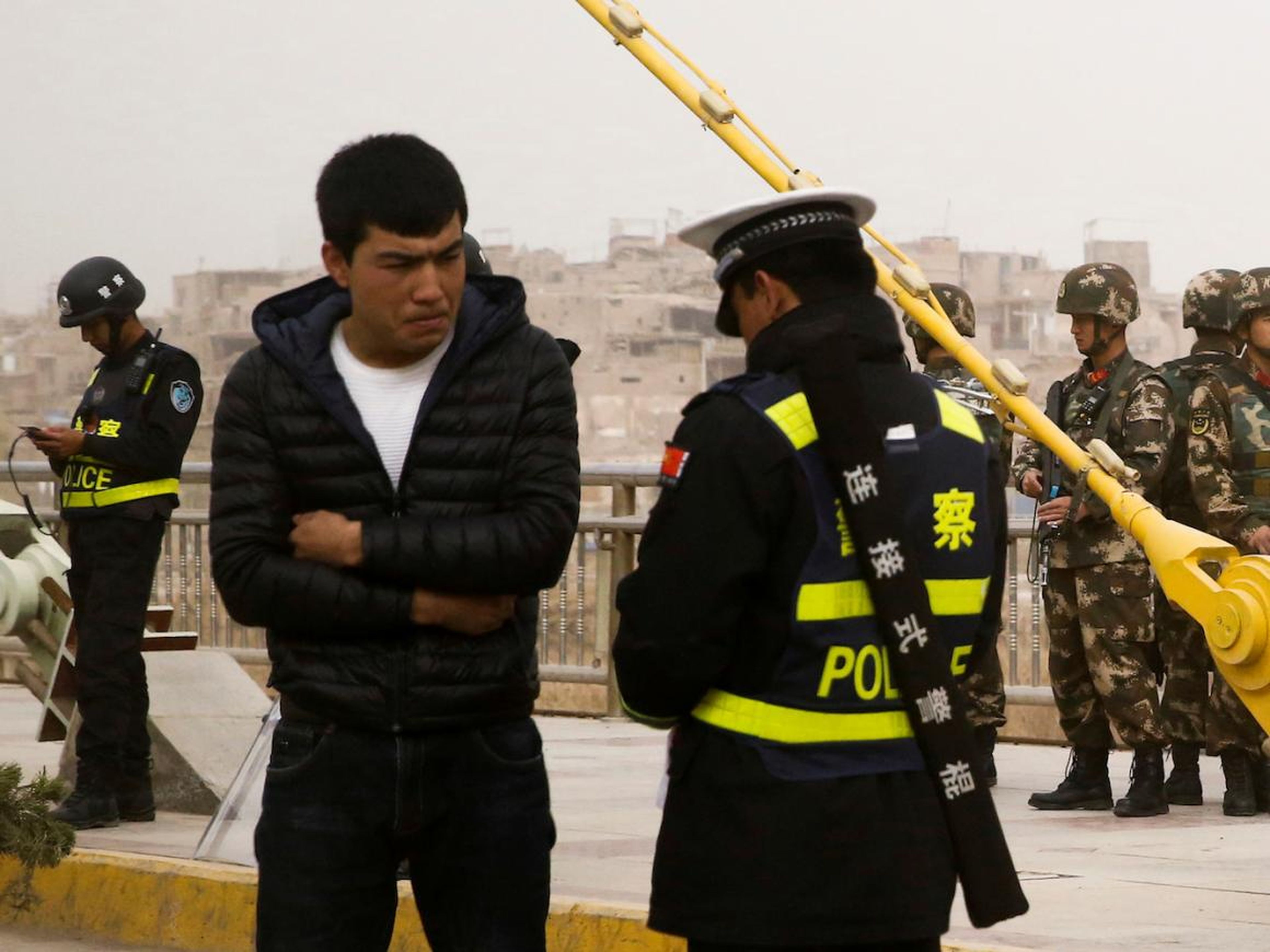 A police officer checks a Uighur man's ID documents in Kashgar, Xinjiang, in March 2017.