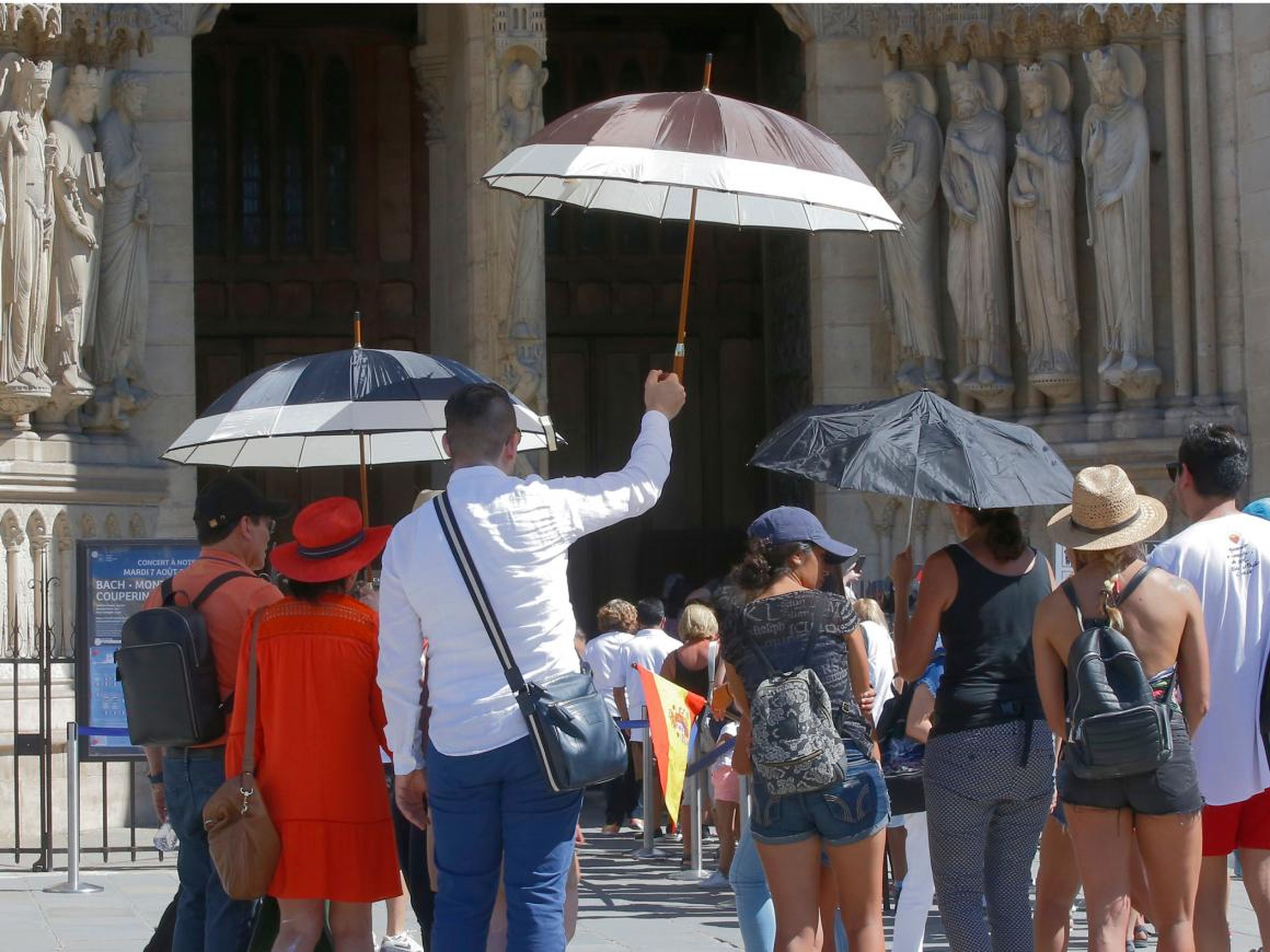 Un grupo de turistas españoles luchan contra el calor abrasador a las puertas de la Catedral de Nottre Dame, en París.