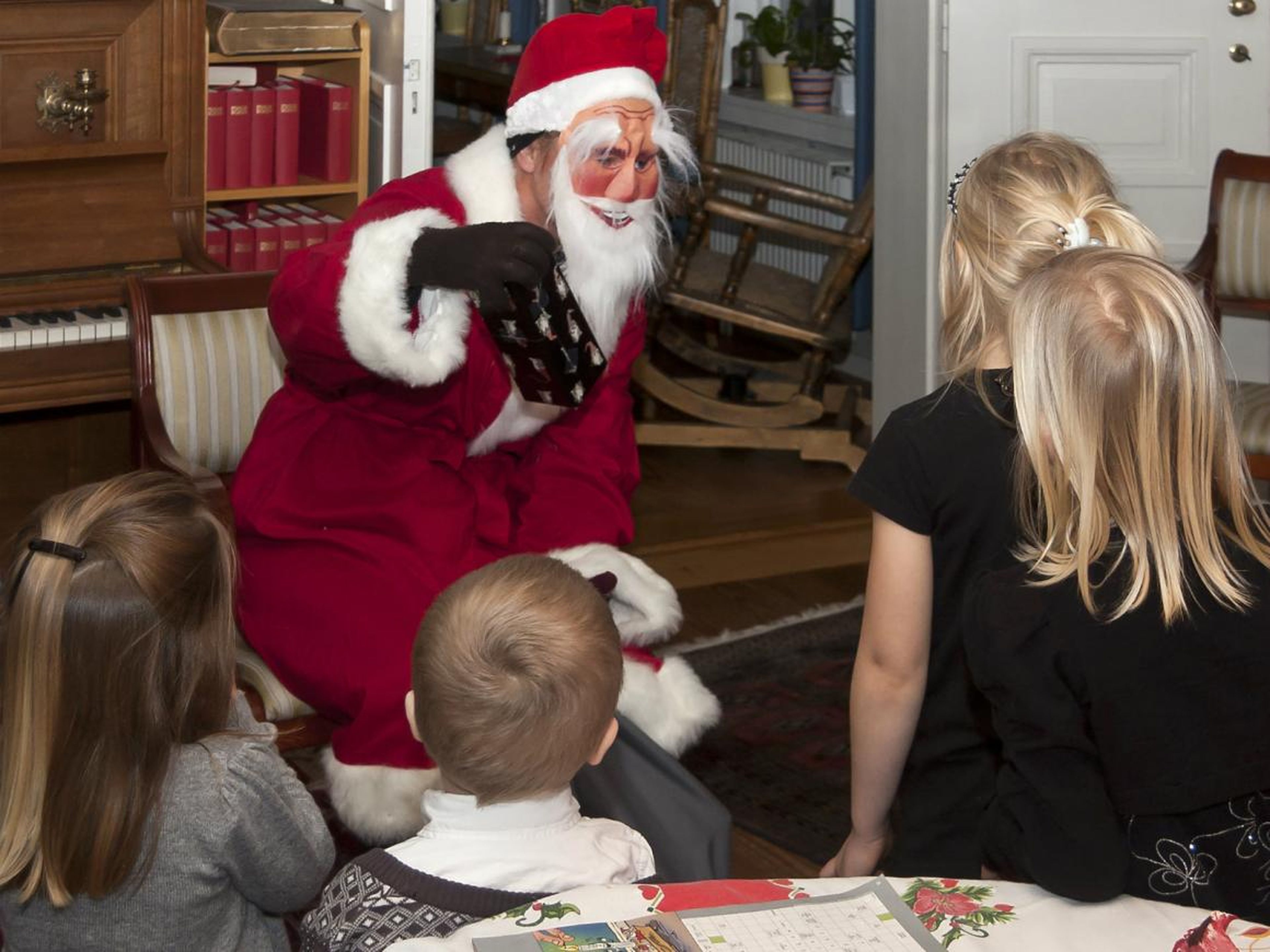 Tomte visits children in a Swedish home on Christmas Eve.