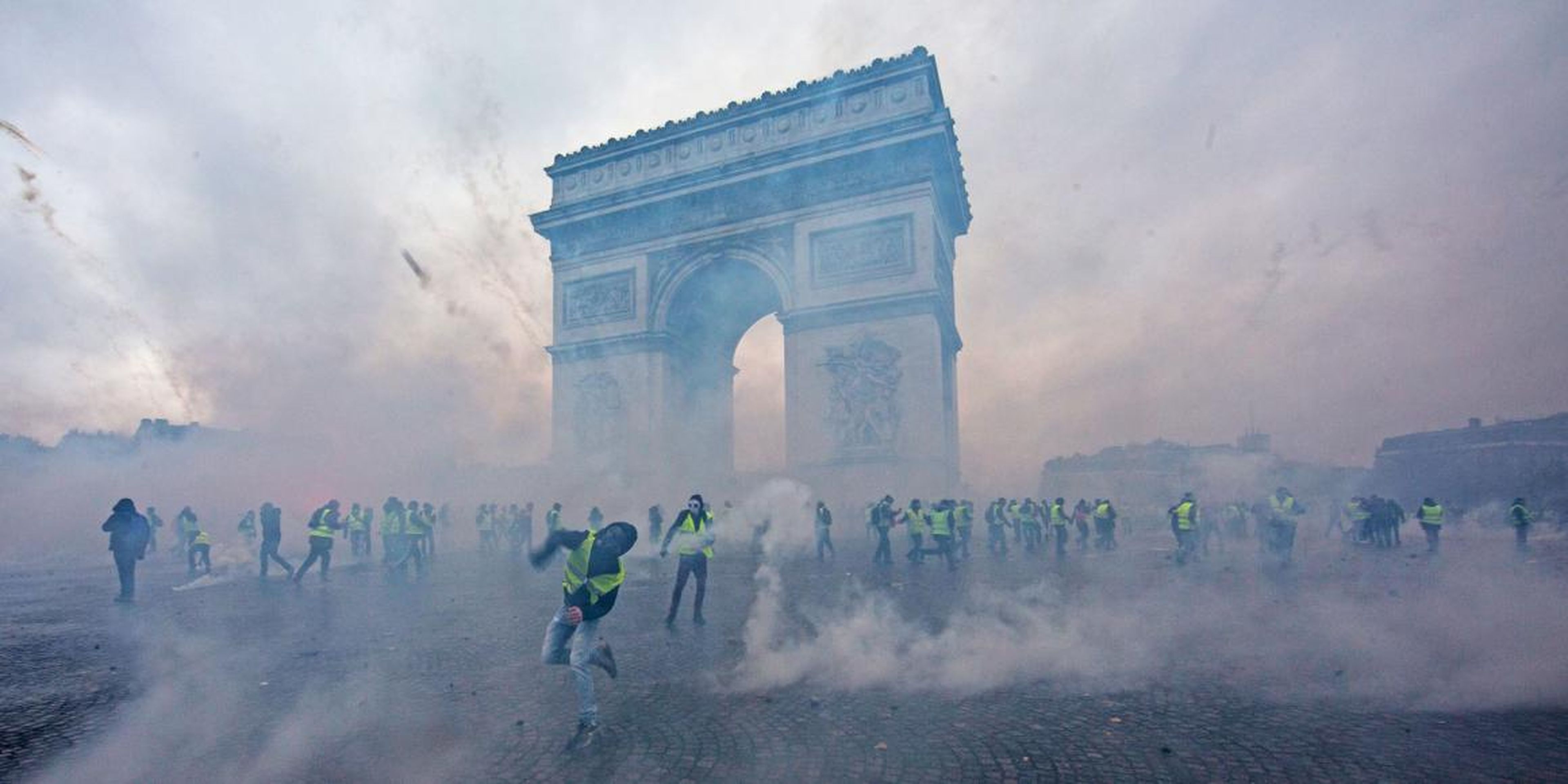 El gas lacrimógeno rodea a los manifestantes durante los choques con los agentes antidisturbios este pasado sábado en el Arco del Triunfo de París