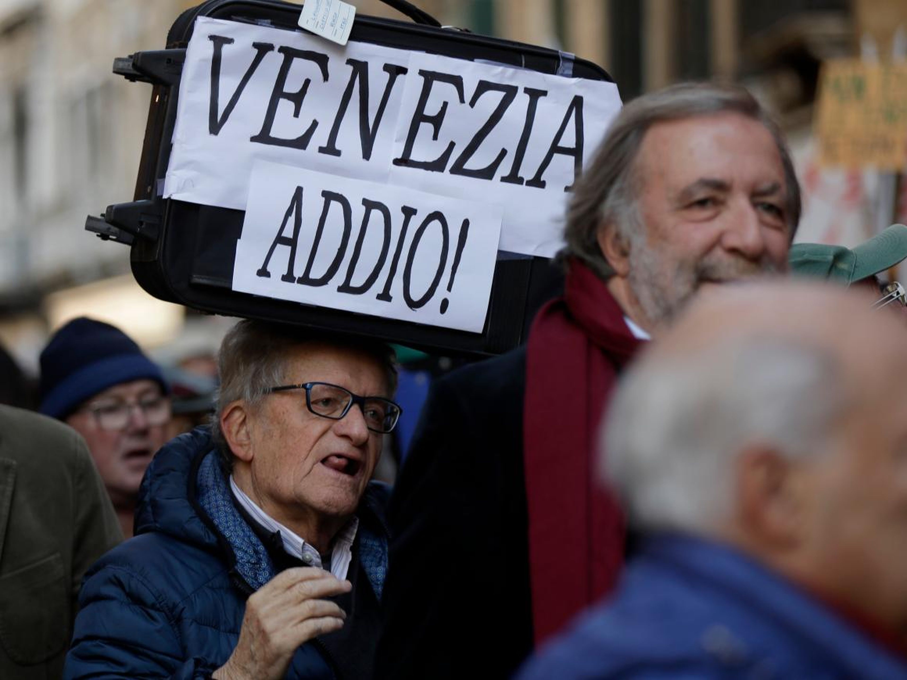 Un manifestante sostiene una pancarta que dice "Adiós Venecia" durante una protesta de 2016.