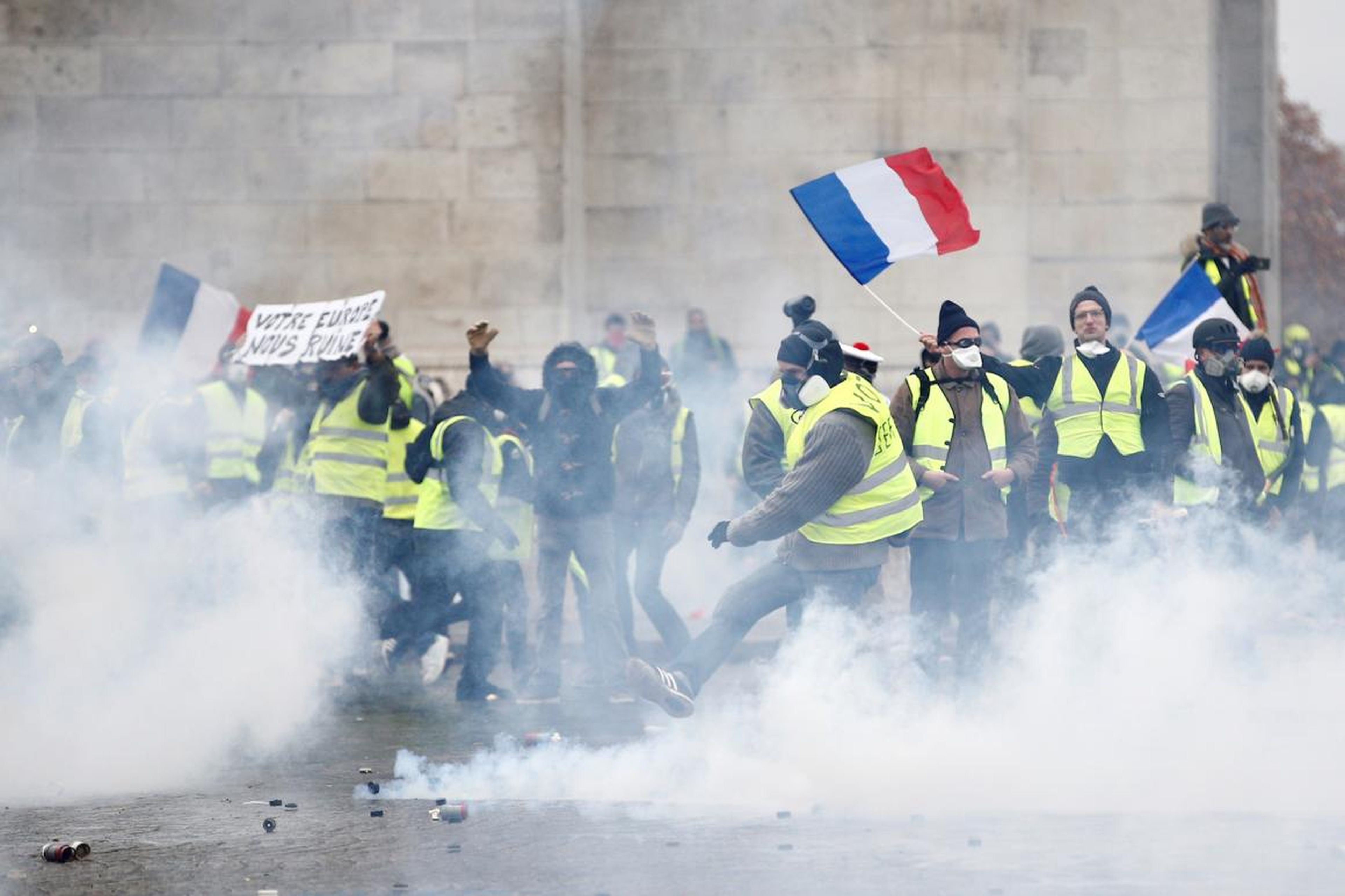 Protesters wearing yellow vests, a symbol of a French drivers' protest against higher diesel taxes, face off with French riot police during clashes at the Place de l'Etoile near the Arc de Triomphe in Paris, France, December 1, 2018.