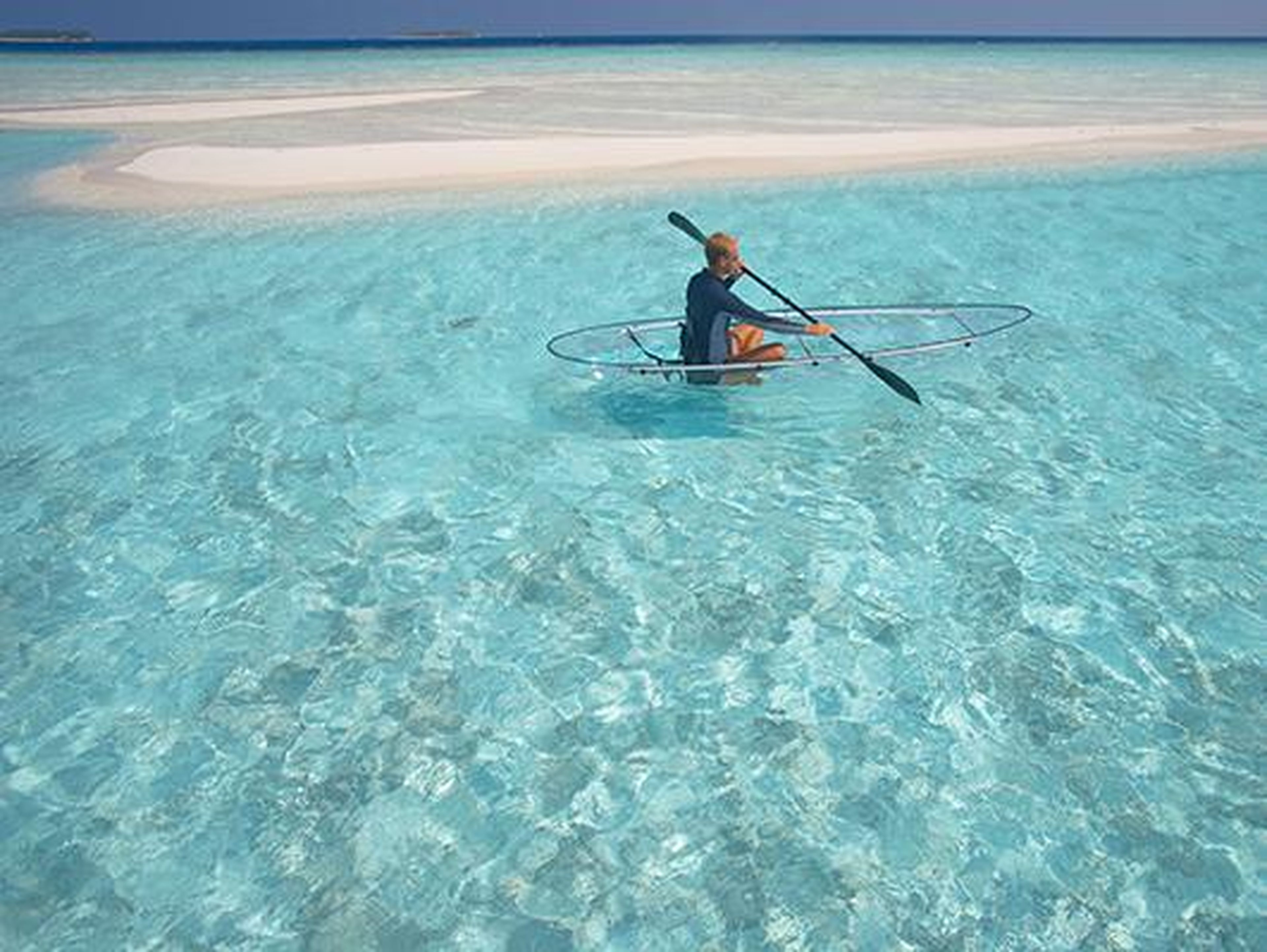 ... and paddling the clear blue waters in a translucent canoe.