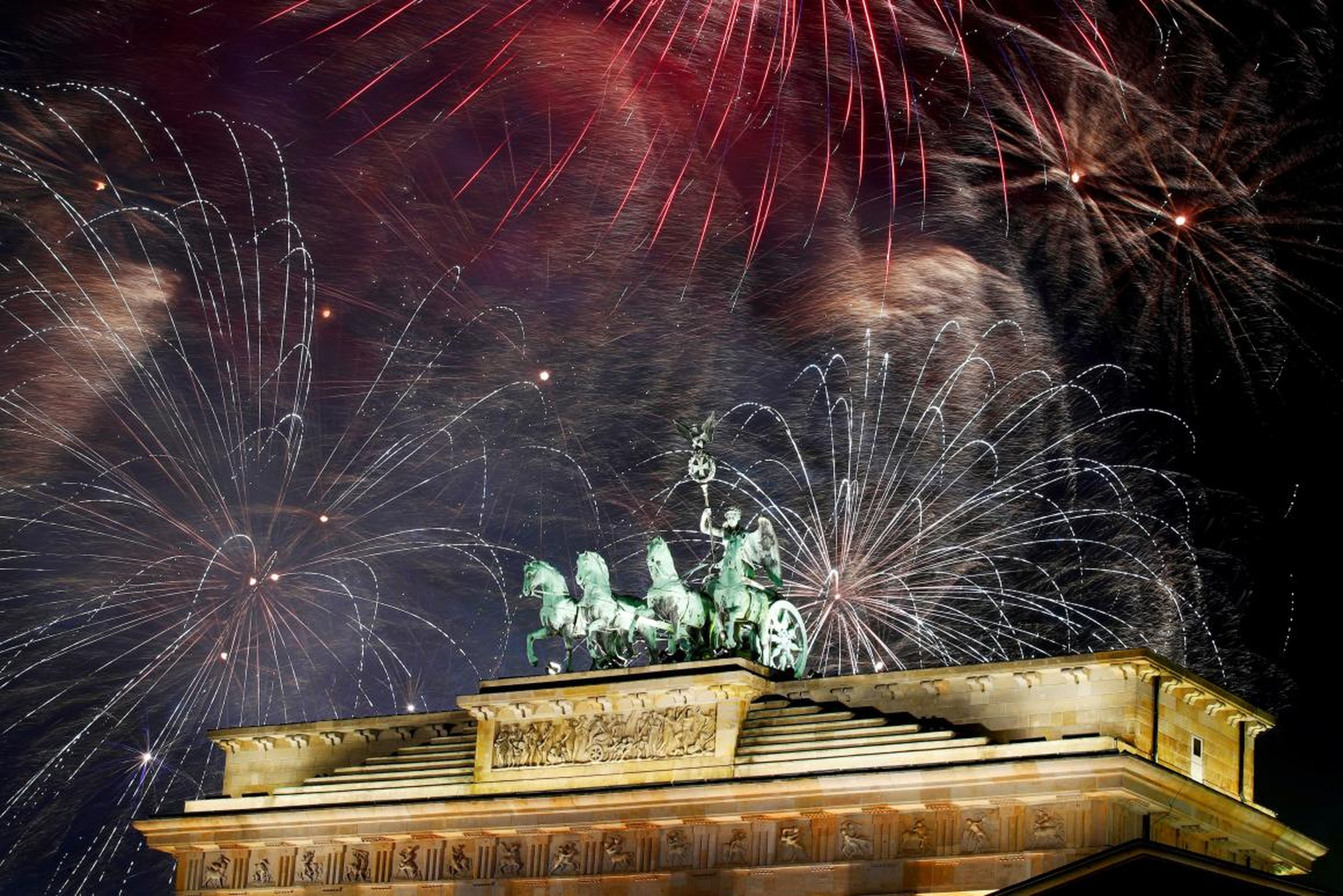 Fuegos artificiales sobre la escultura de la Cuadriga en la puerta de Brandenburgo durante las celebraciones de Año Nuevo en Berlín, Alemania, el 1 de enero de 2019.