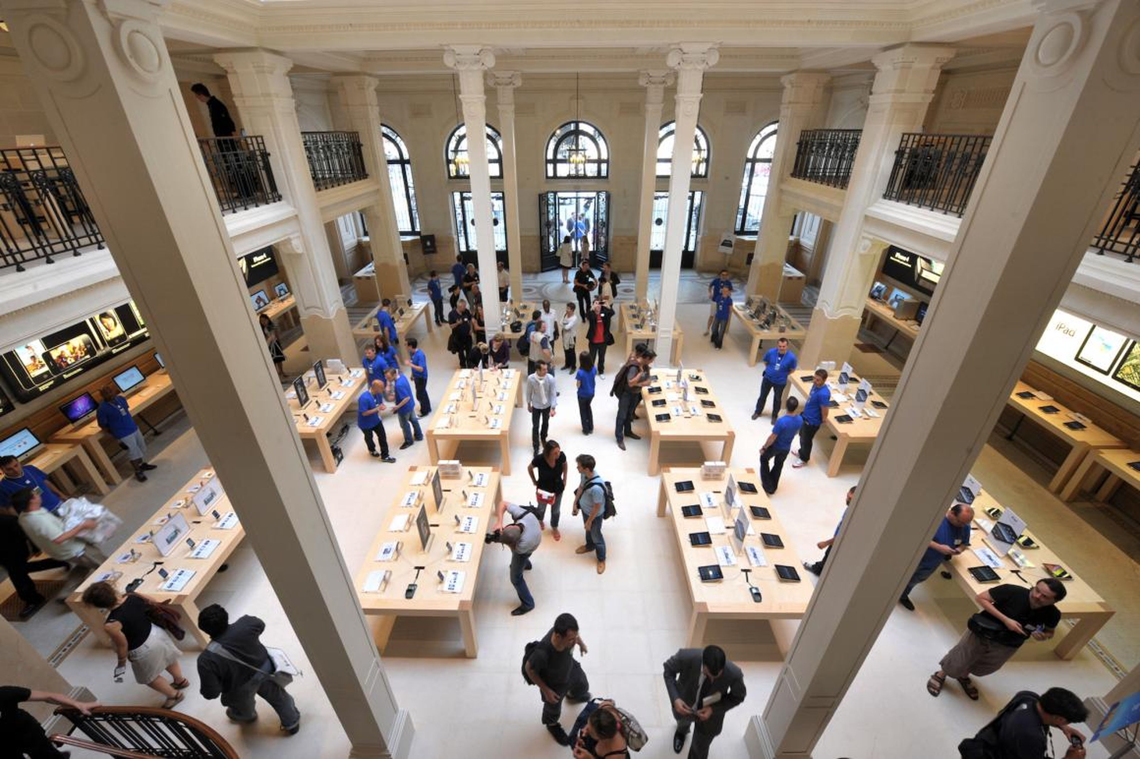 Inside, you will find a typical looking Apple store, but with a historic feel. White pillars stand strikingly tall, and black balcony railings cut through the space. Light shines down through a large-scale skylight.