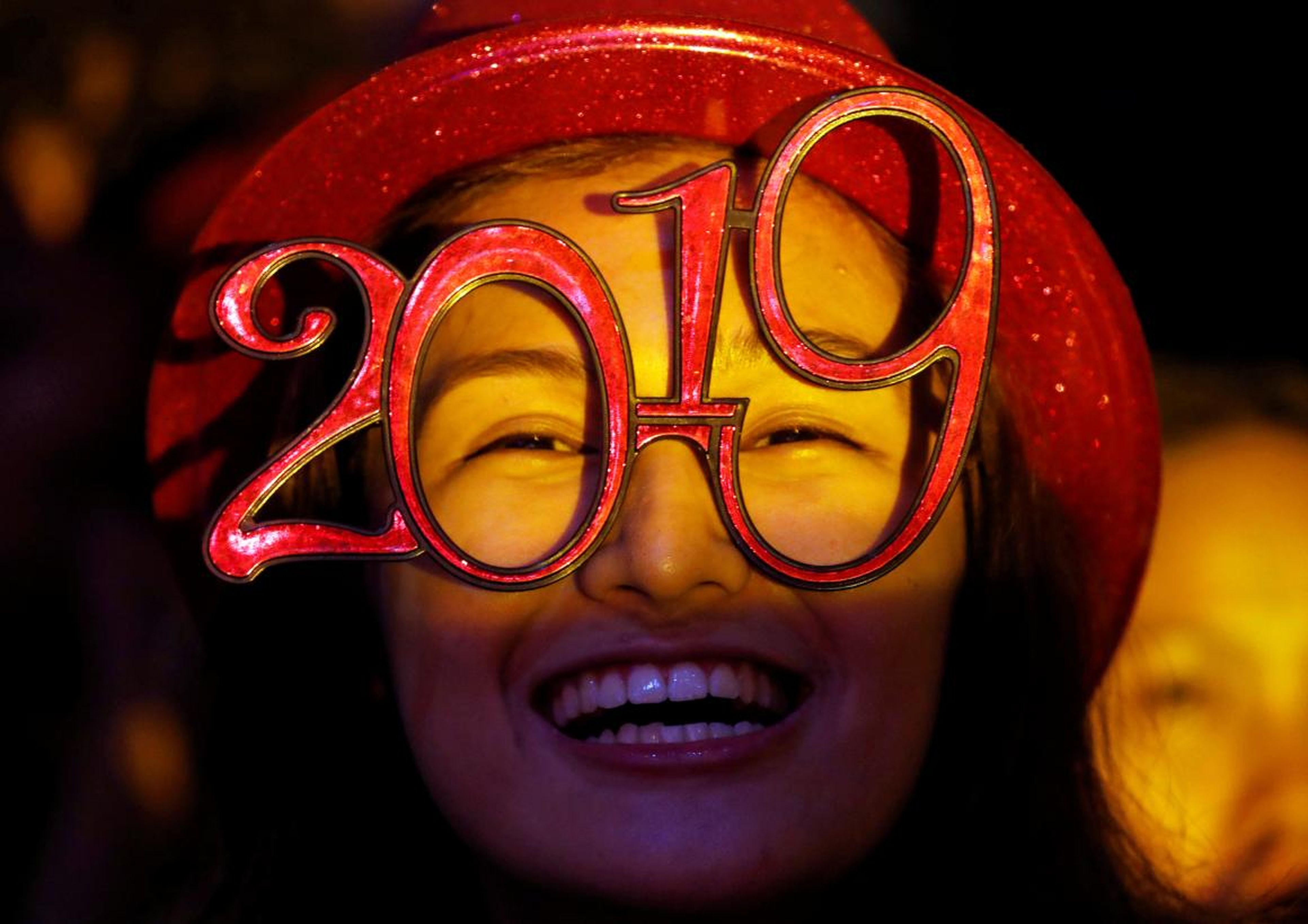 Una mujer lleva gafas con forma de año 2019 durante la fiesta de Nochevieja en Quezón, Metro Manila, Filipinas, el 31 de diciembre de 2018.