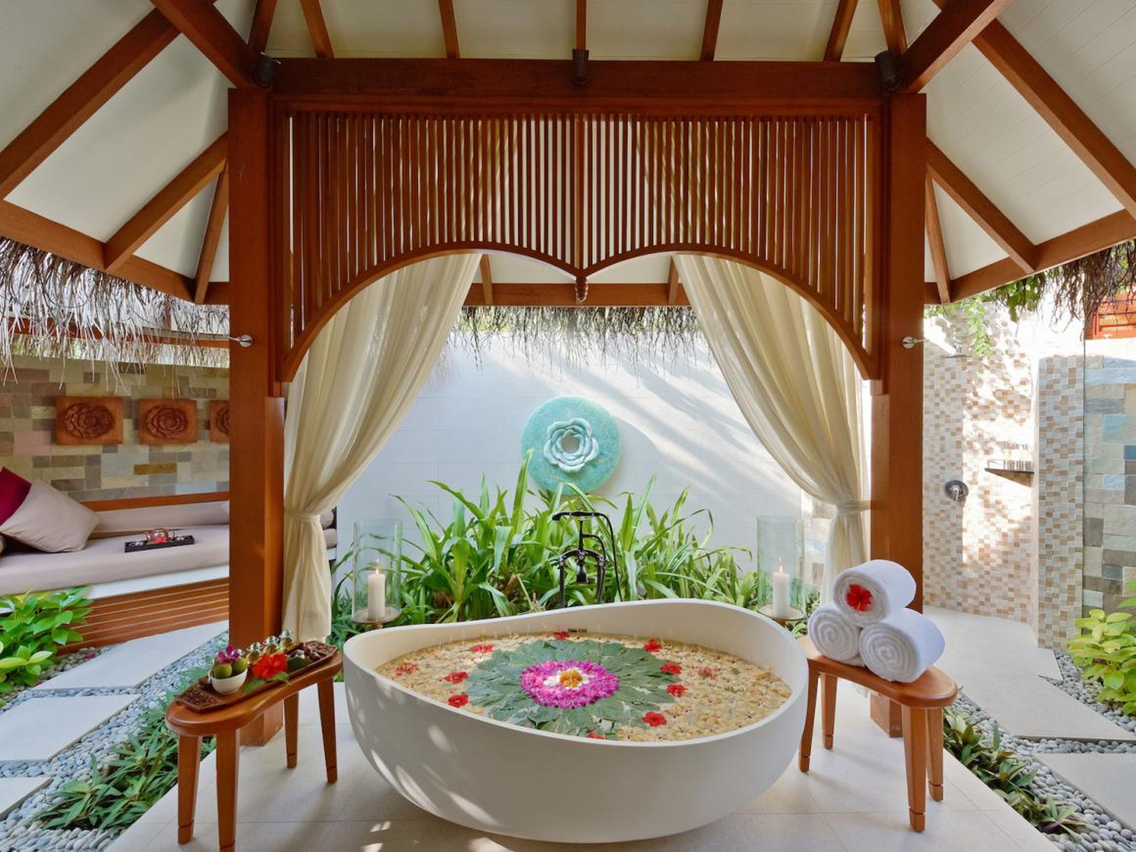 A steam bath and outdoor relaxation area with bathtub and rainfall shower in a tropical garden is included with every suite.
